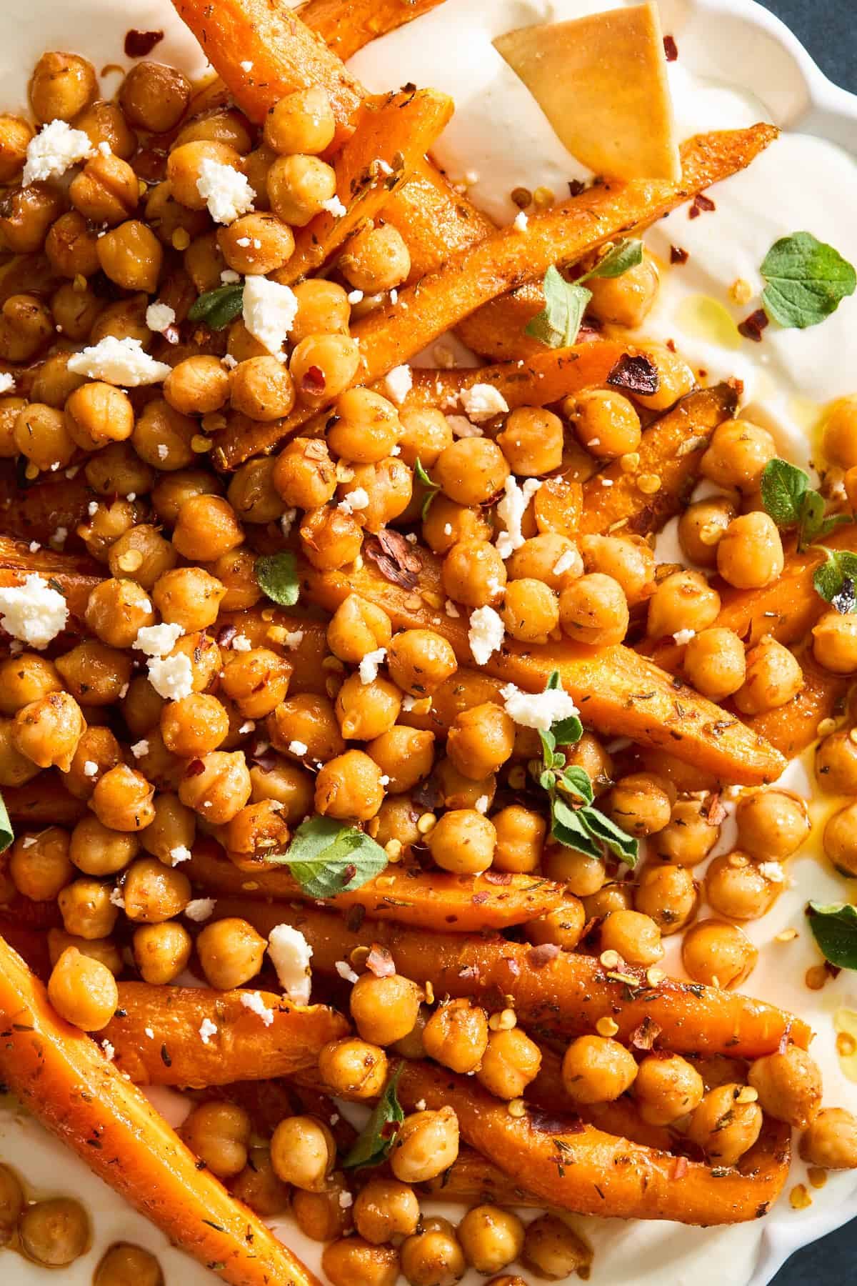 Close up image of chickpeas and roasted carrots over whipped feta.