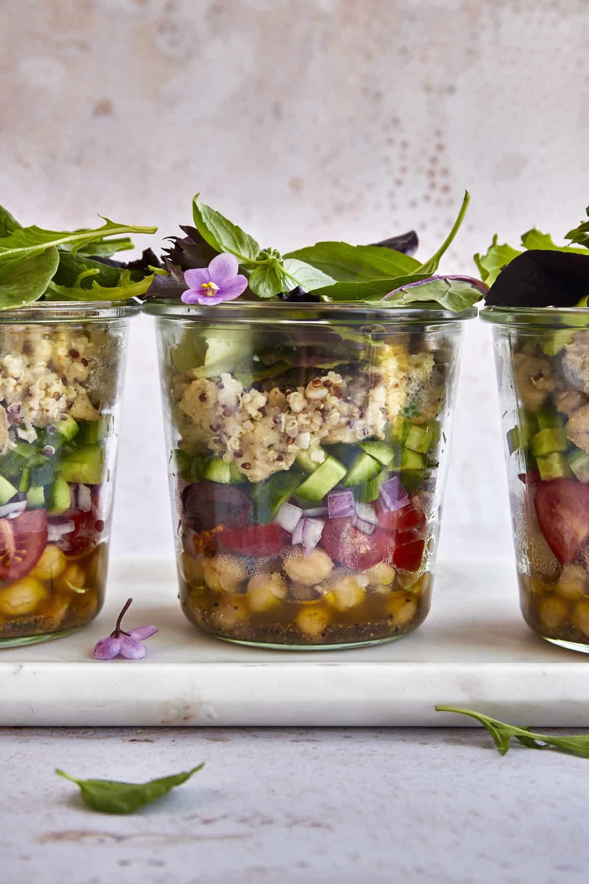 Three Mediterranean quinoa salad in a jar portions.