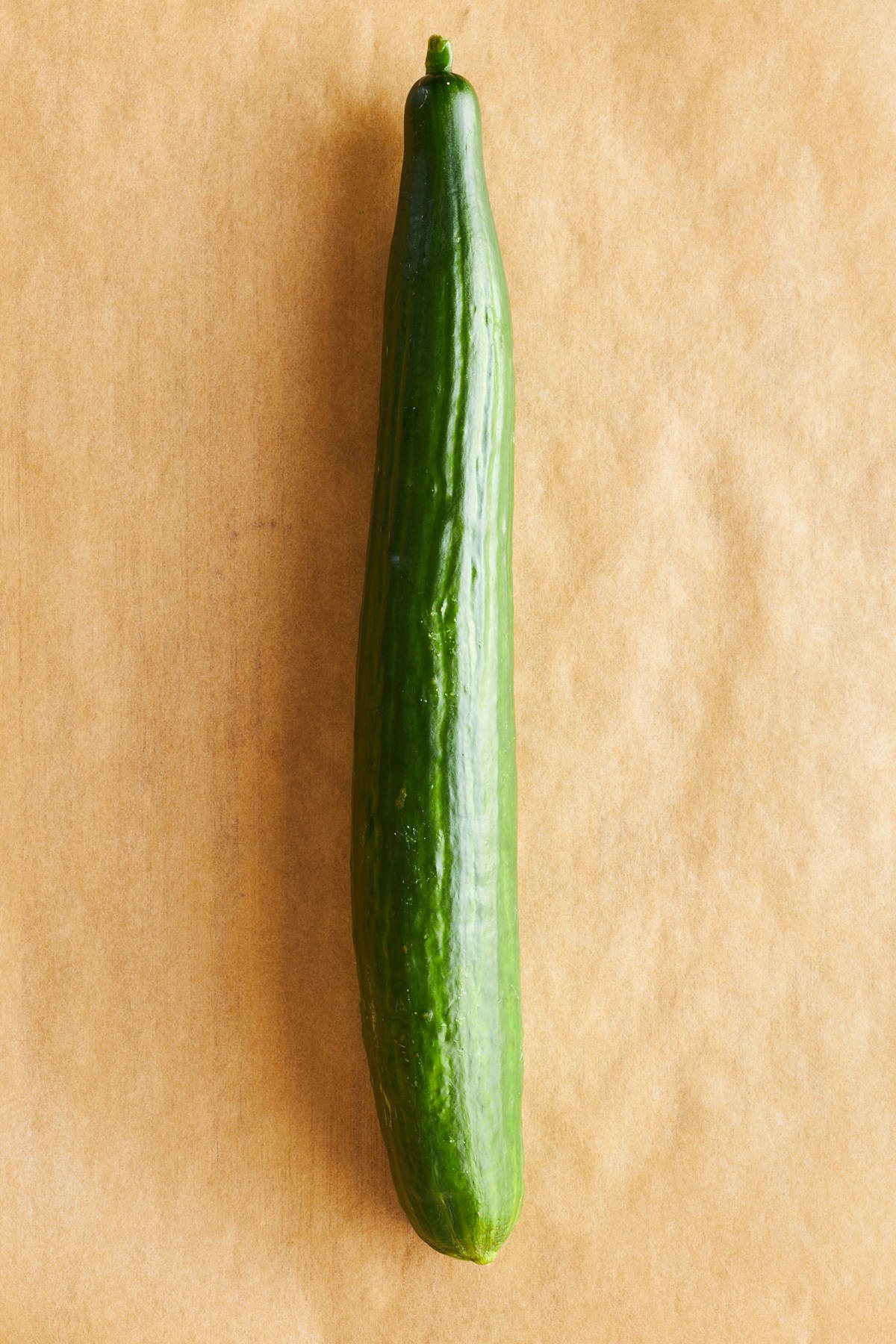 A large cucumber on a piece of parchment paper.