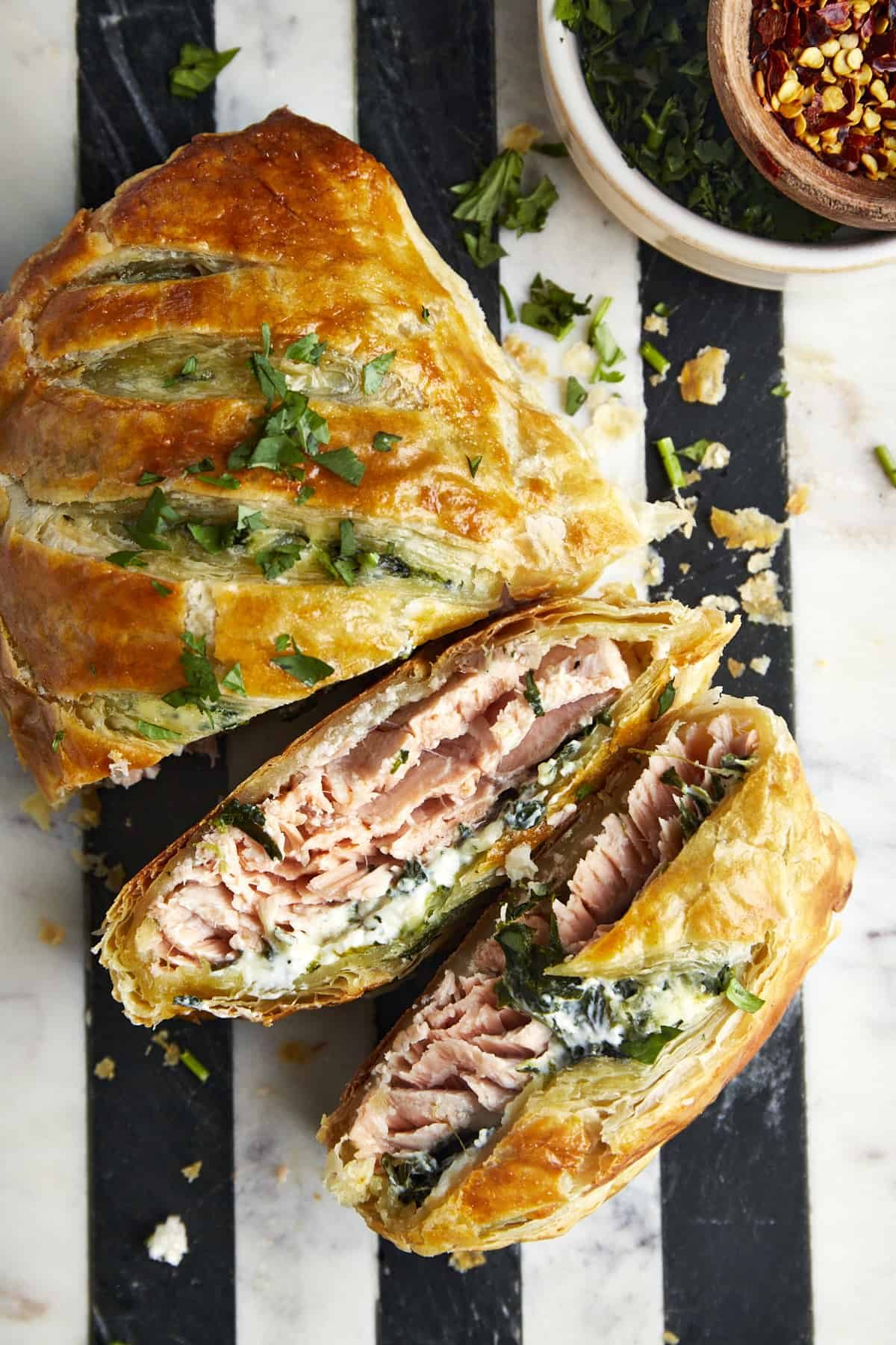 Salmon Wellington with two pieces sliced exposing the interior.
