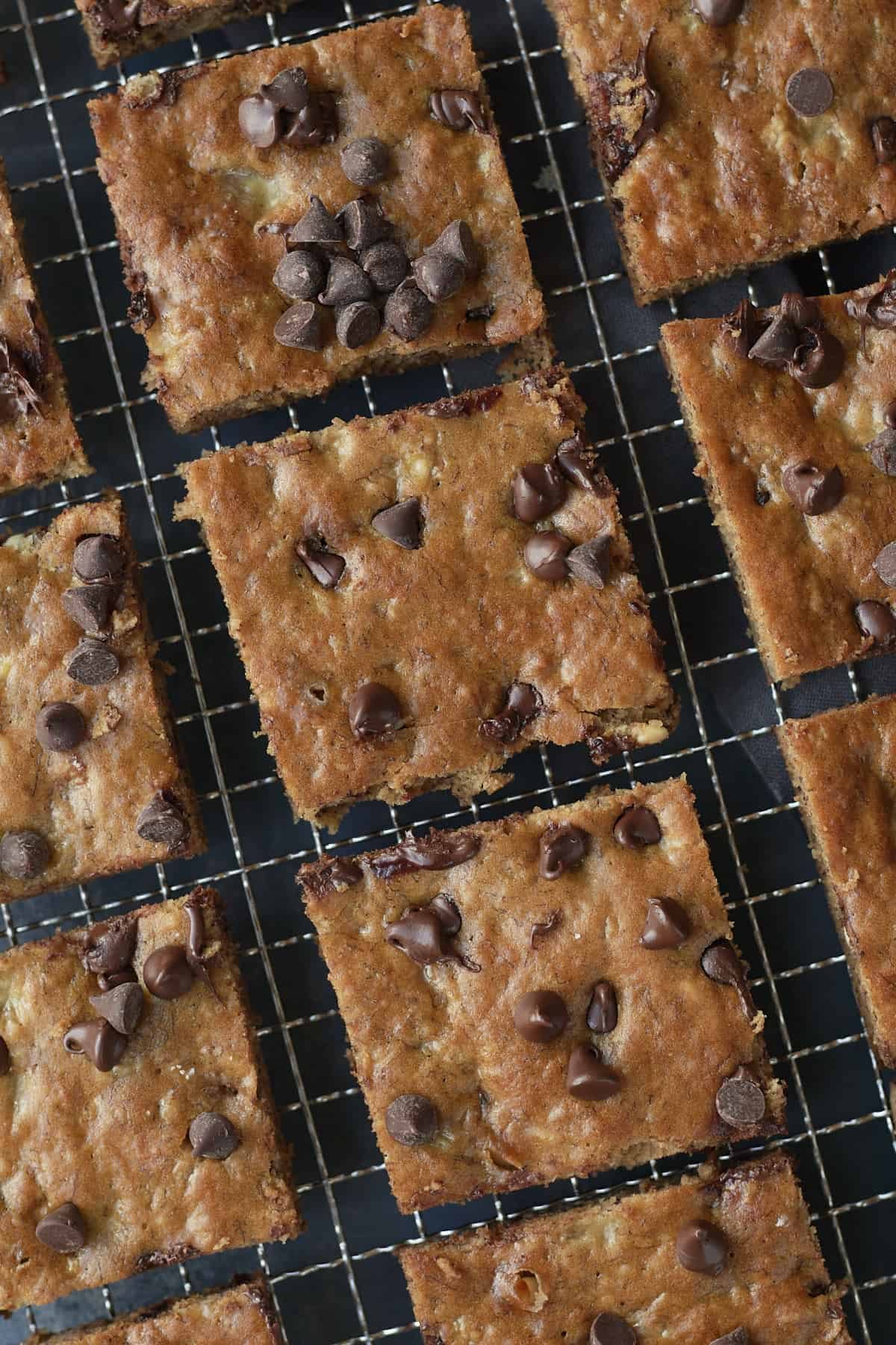 banana bread cut into squares and placed on a cooling rack.