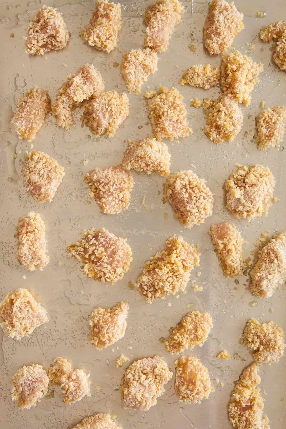 Raw pieces of breaded chicken.
