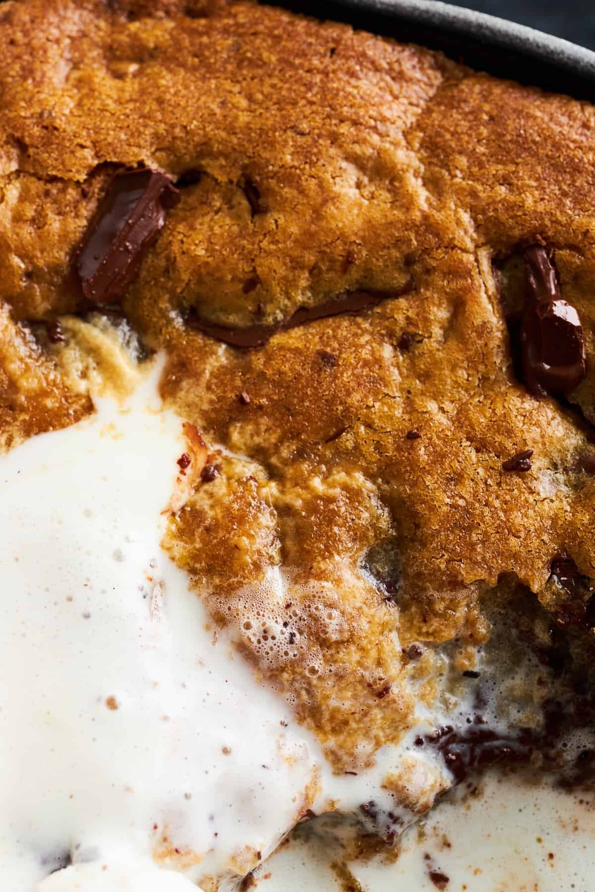 Close up image of a chocolate chip cookie skillet with vanilla ice cream.