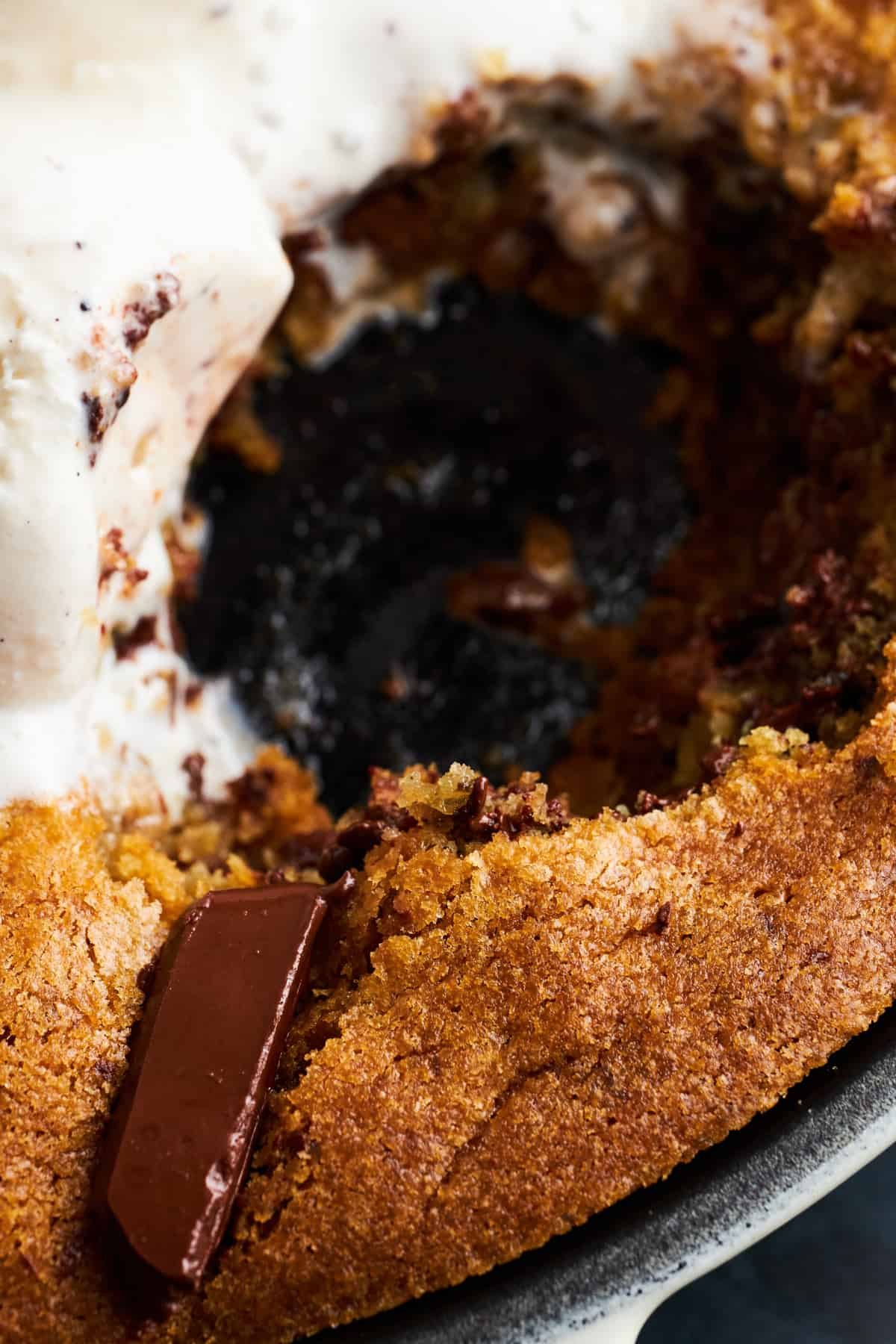 A skillet chocolate chip cookie with a bite missing.