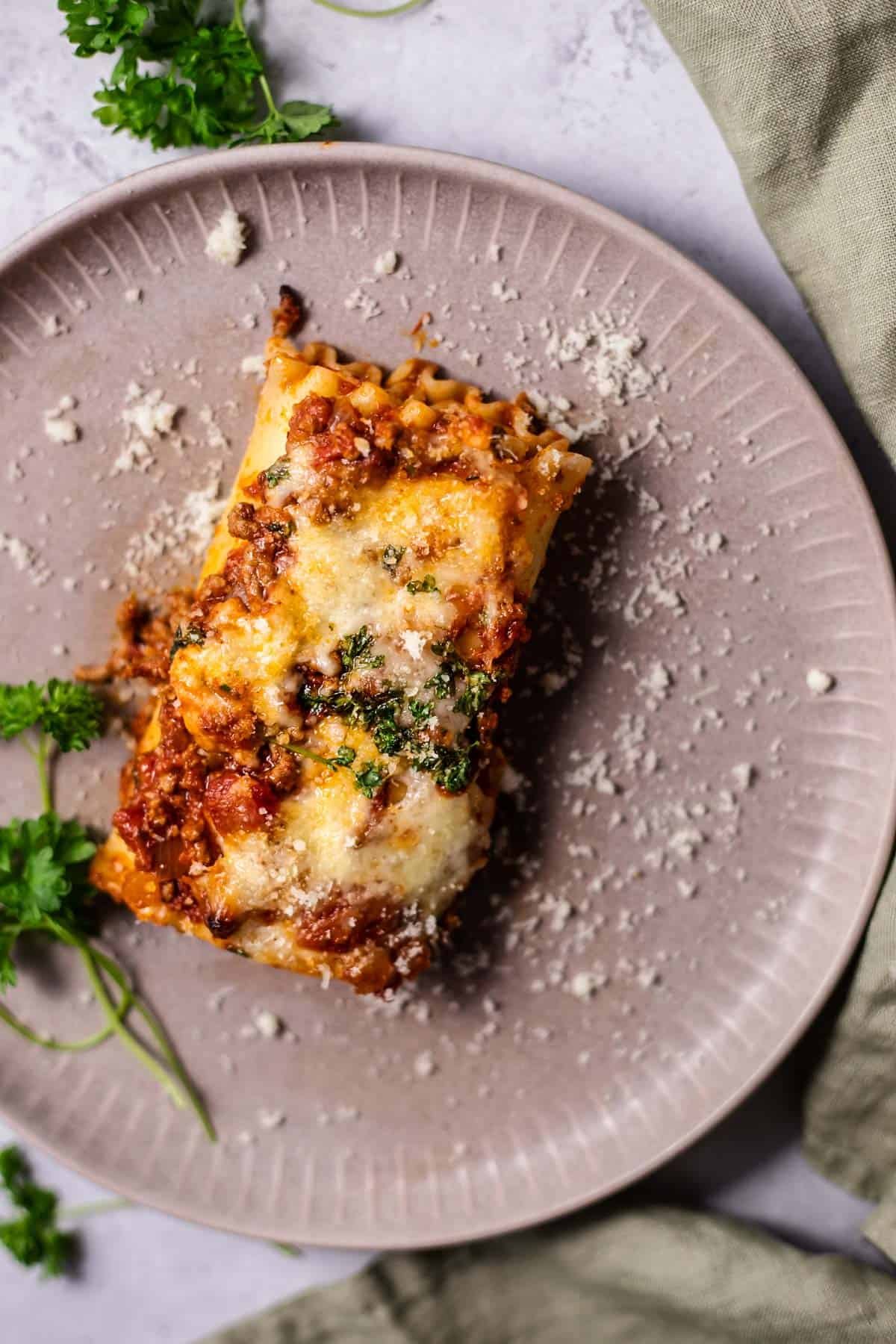 a baked lasagna roll on a light purple plate