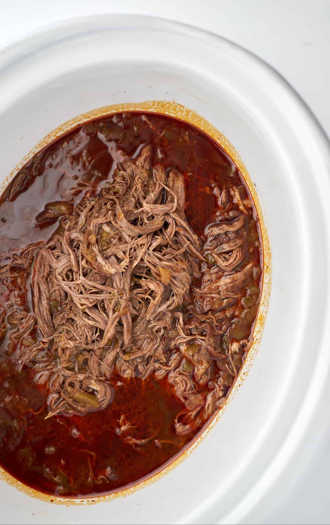 beef birria meat in a slow cooker