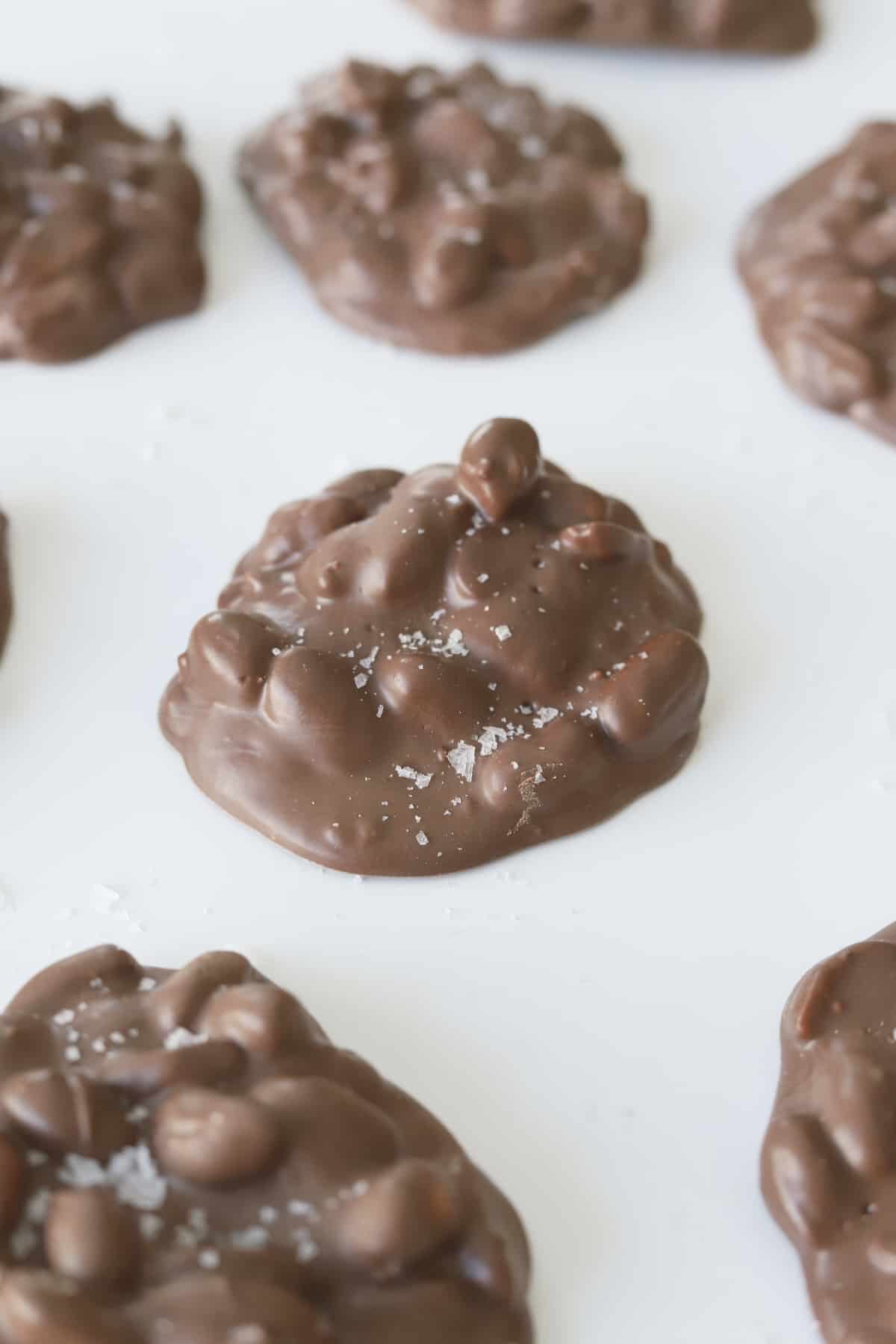 chocolate peanut slow cooker candy clusters topped with salt