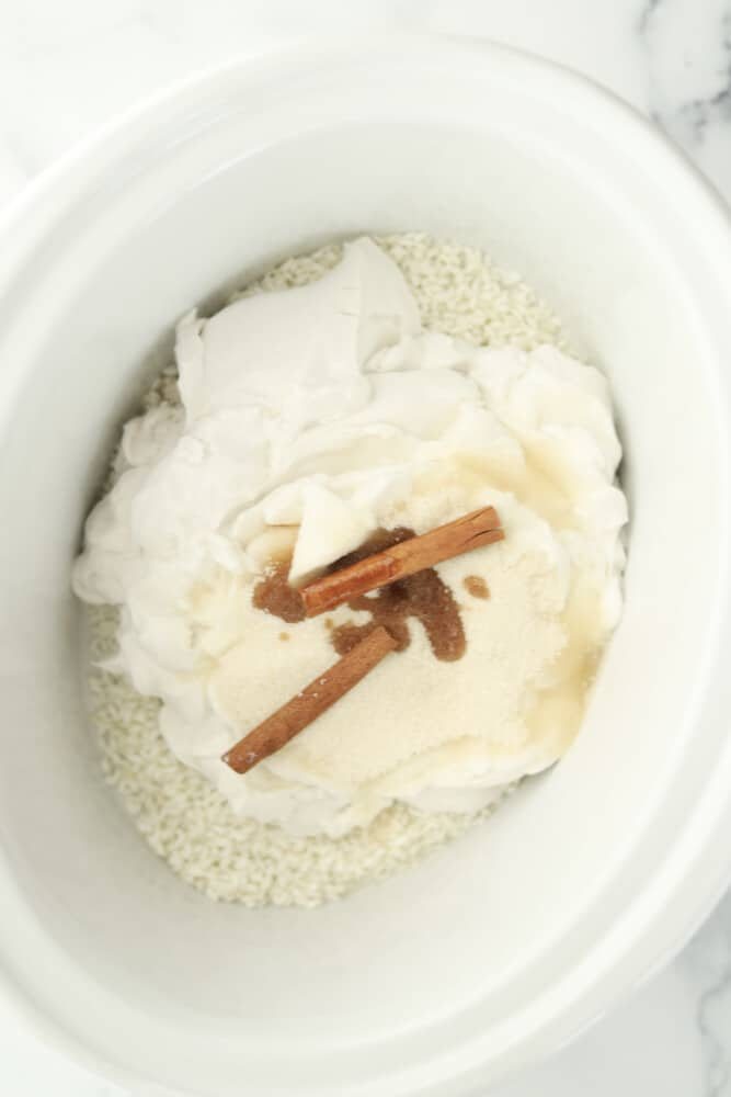 rice, coconut milk, sugar, vanilla, and cinnamon sticks in a slow cooker