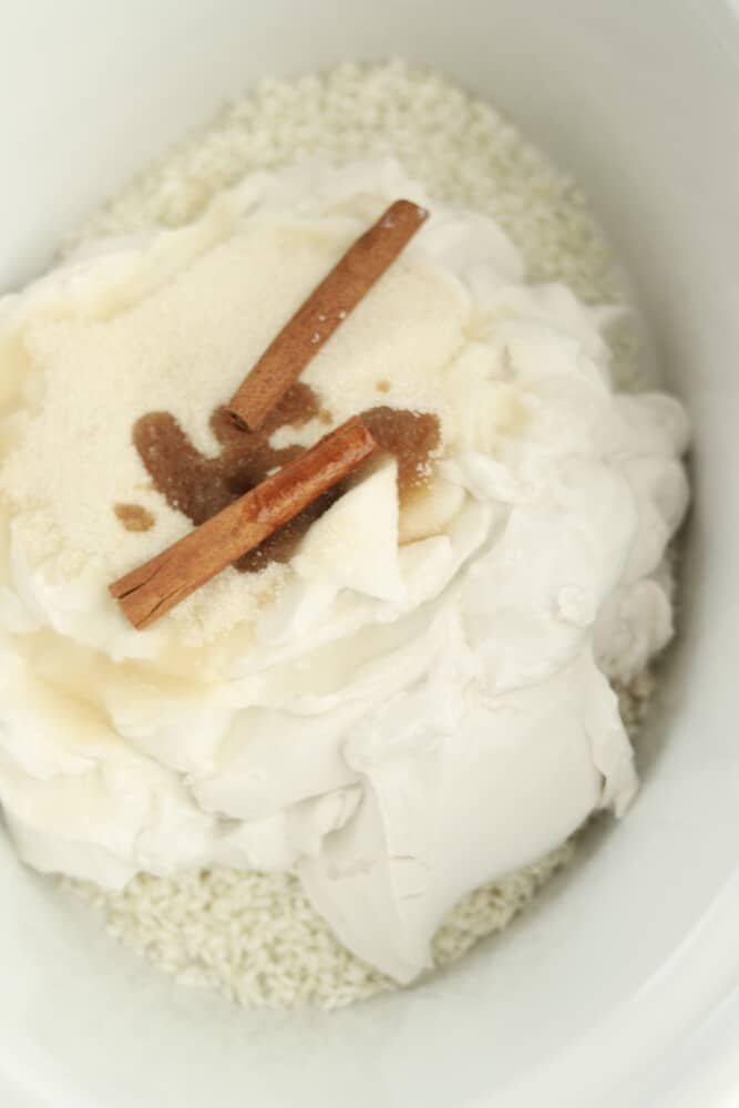 rice, coconut cream, sugar, vanilla, and cinnamon sticks in a slow cooker