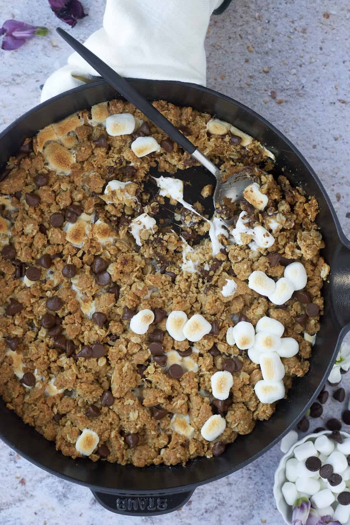 s'mores oatmeal cookie skillet with a spoon dipped in.