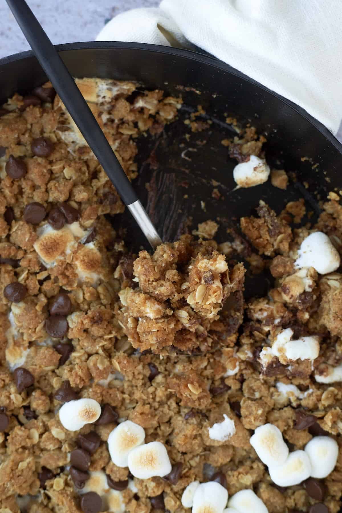 a spoon holding a bit of a s'mores cookie skillet.