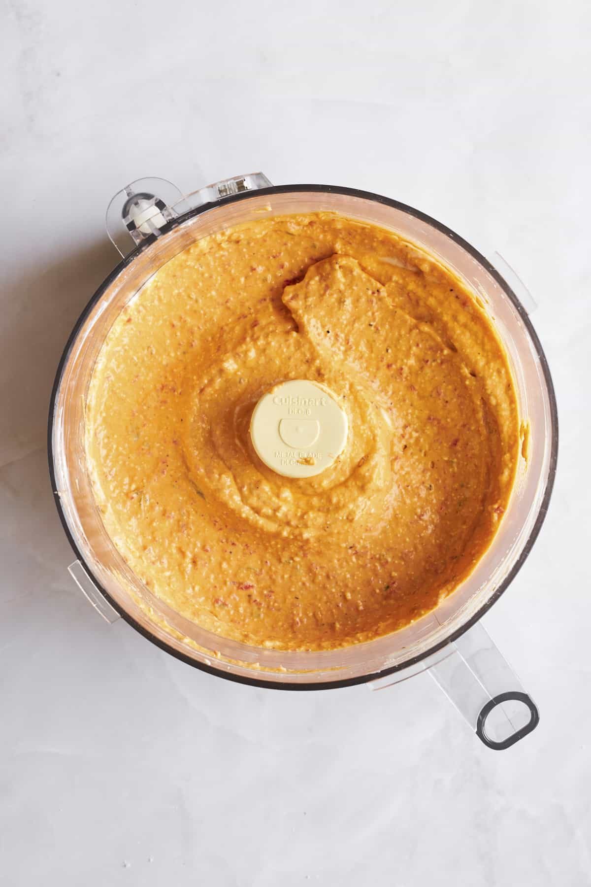 Blended spicy feta dip in a food processor.