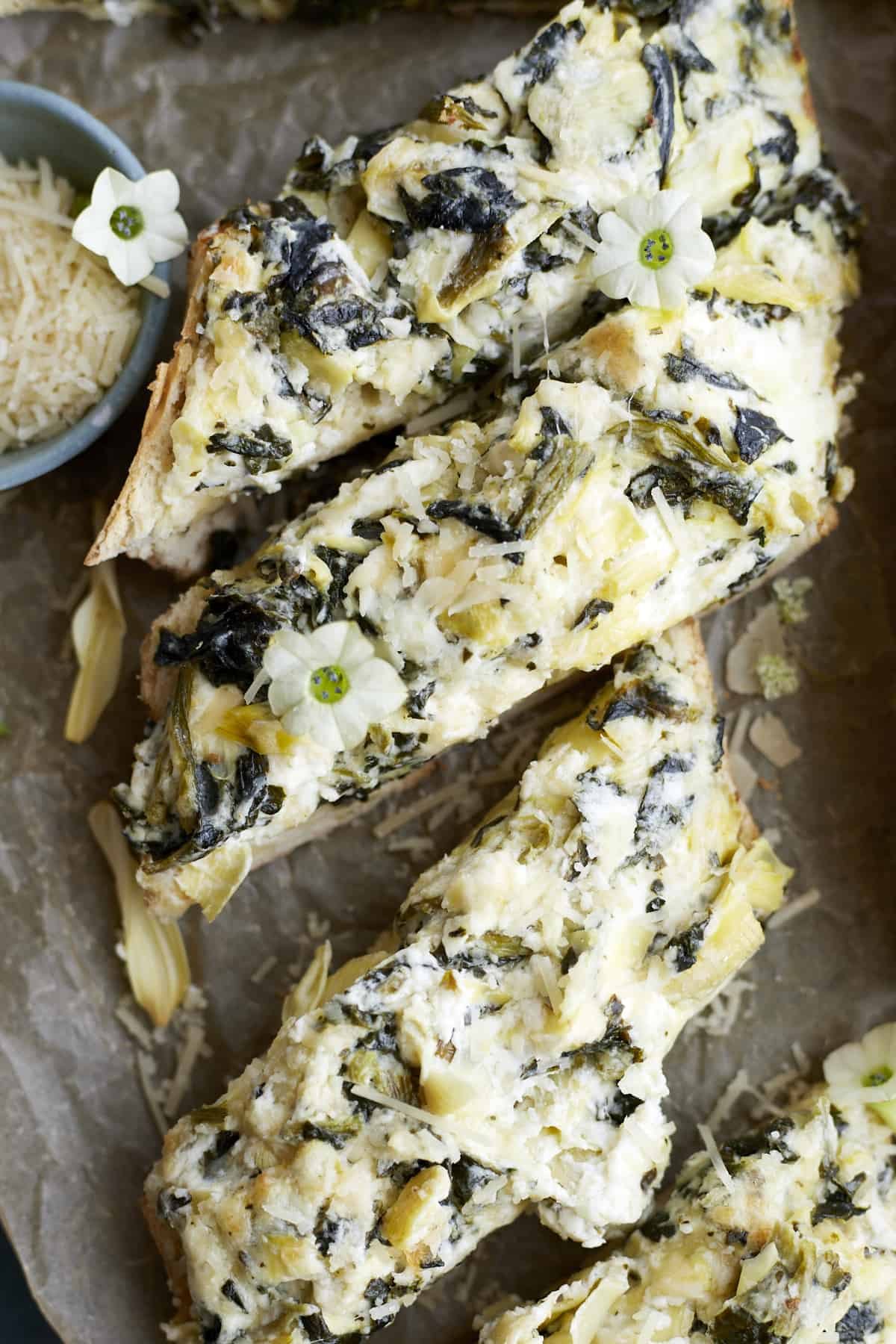 sliced pieces of from-scratch garlic bread with spinach and artichokes