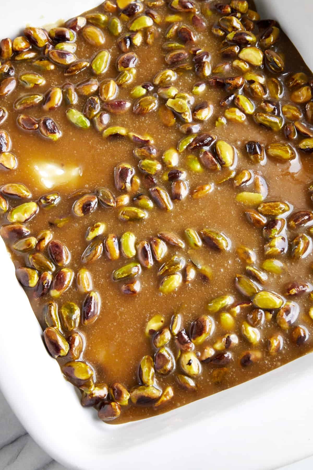 A caramel pistachio sauce in a baking dish.
