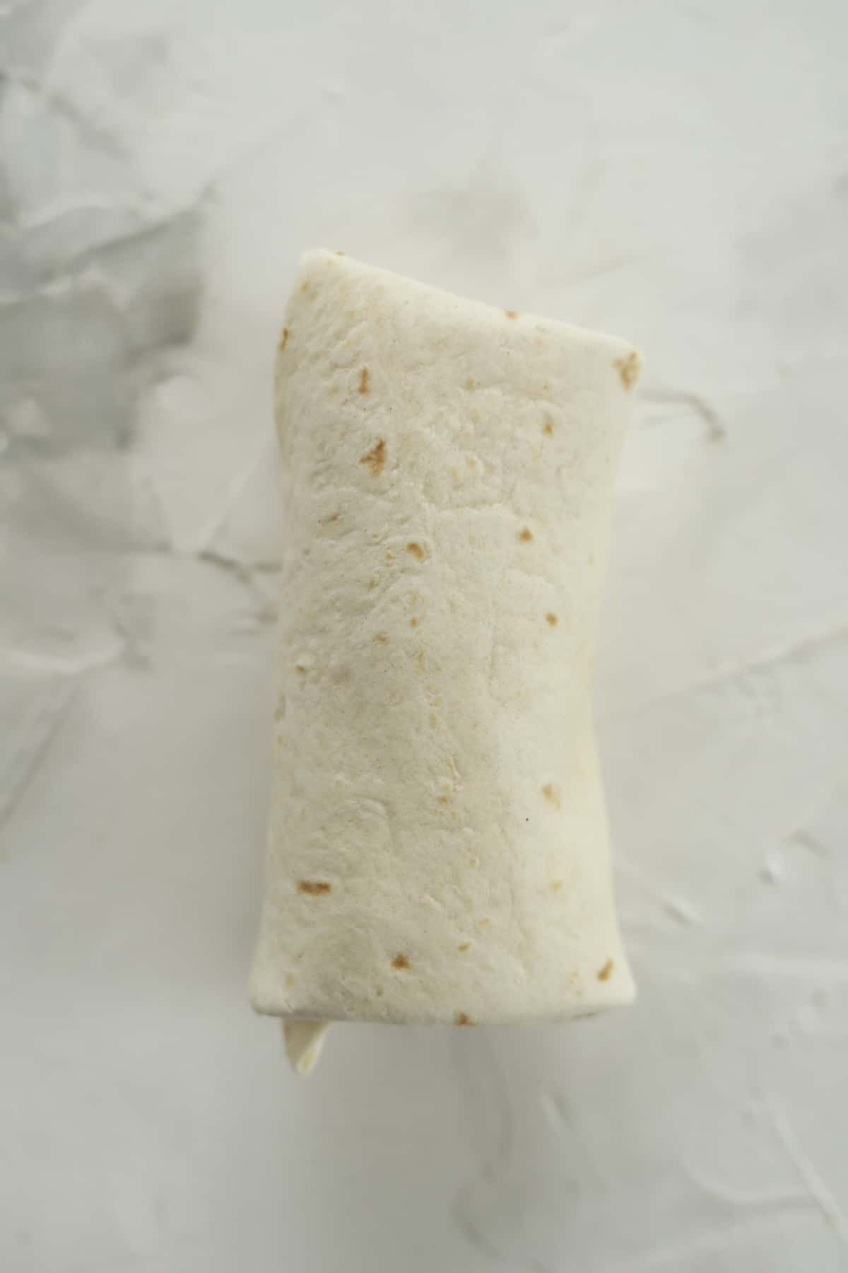 an uncooked strawberry cheesecake chimichanga