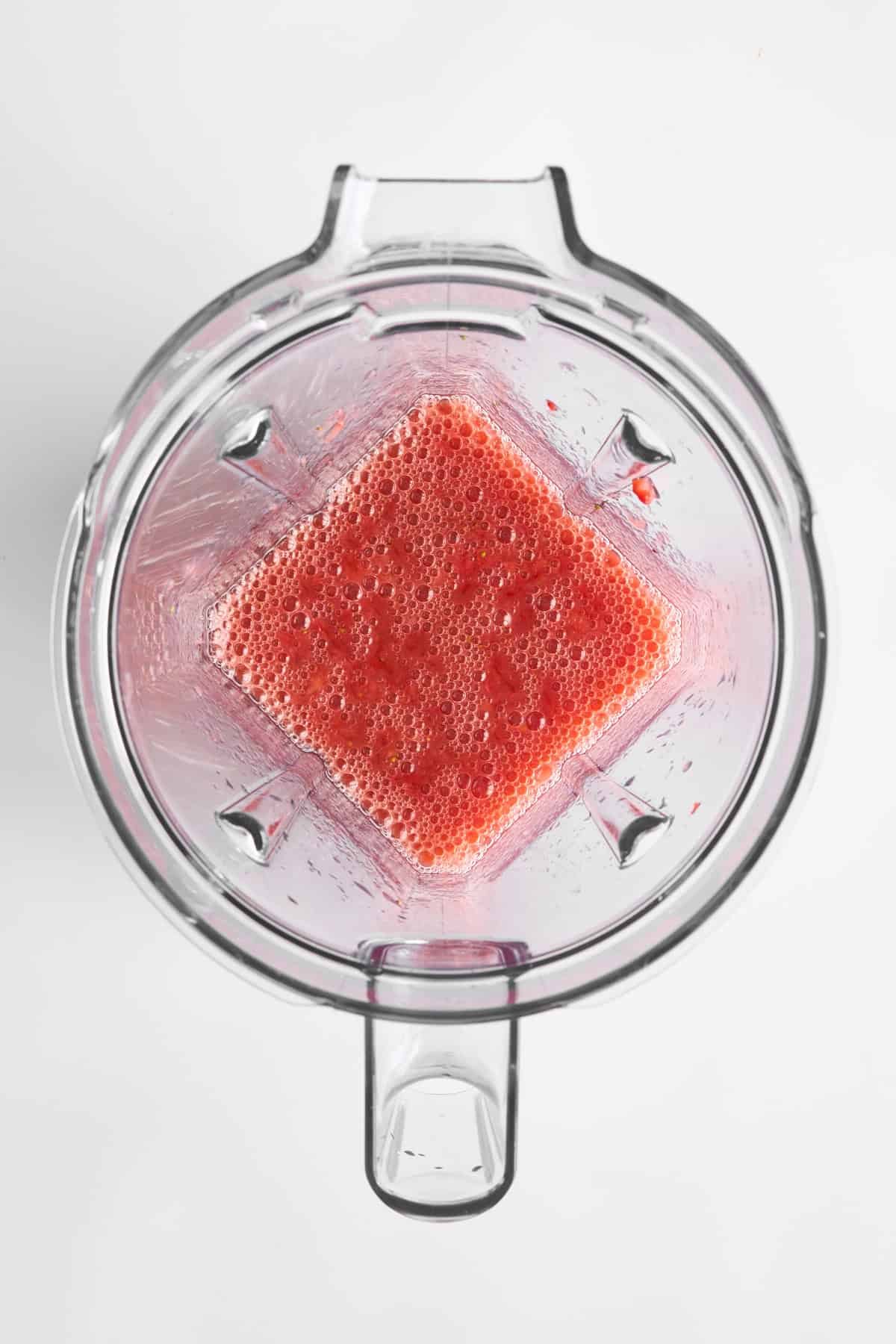 Strawberries pureed in a blender.