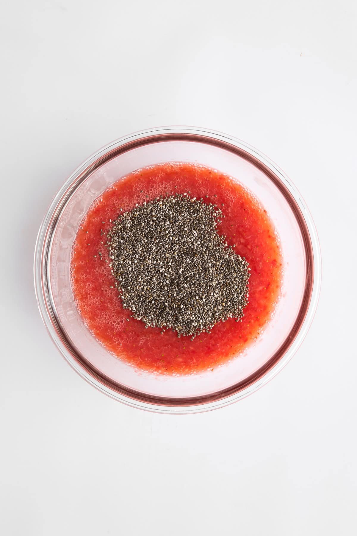 Strawberry puree and chia seeds in a bowl.