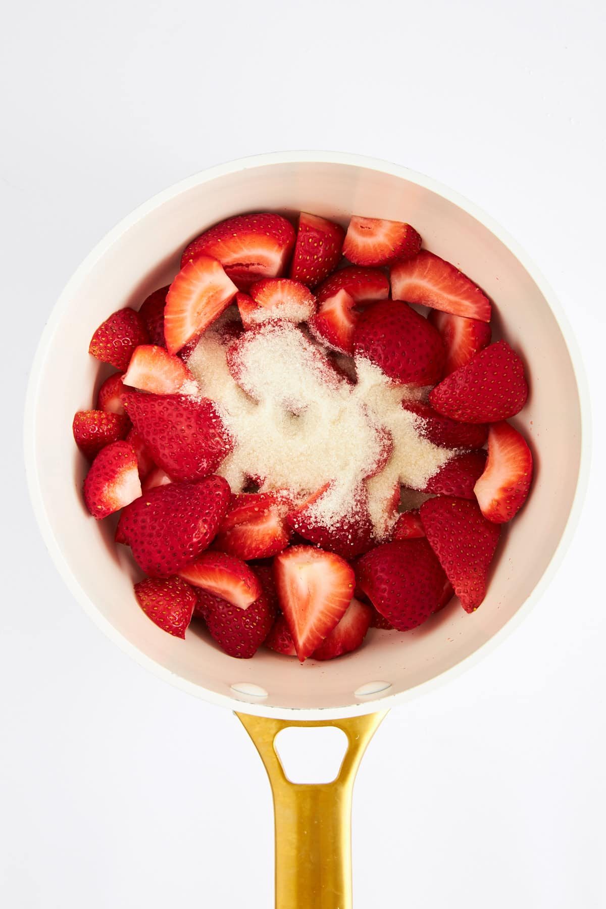 Sugar and strawberries in a saucepan.