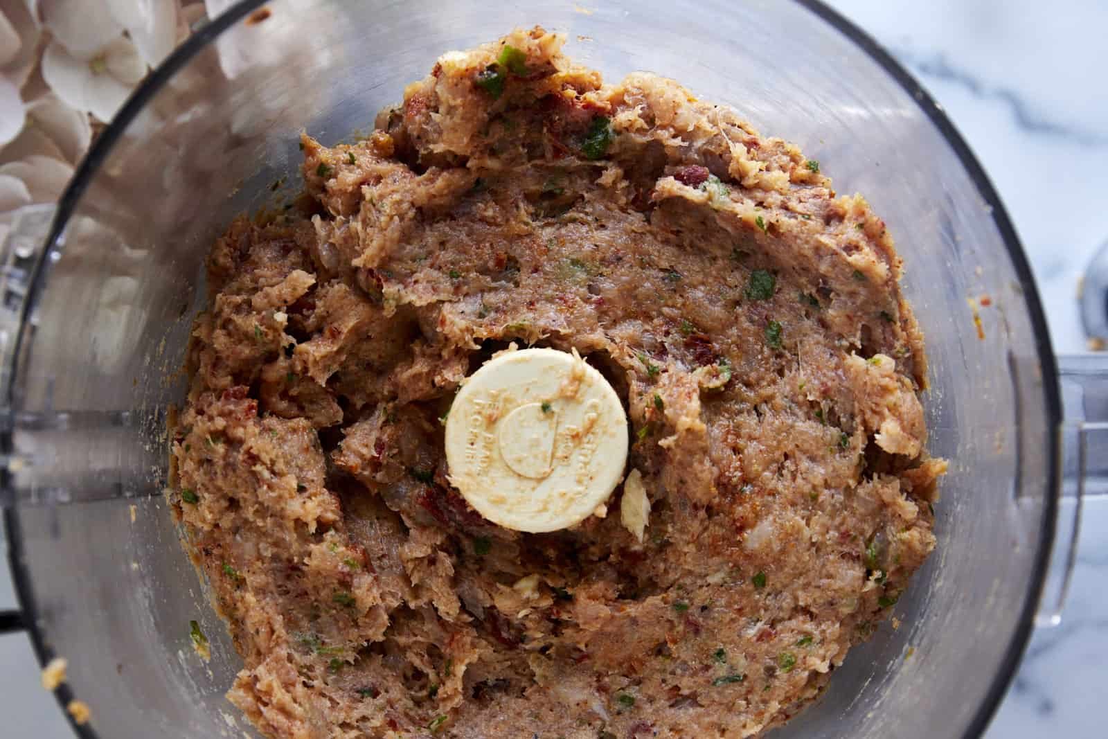 Raw chicken meatball mixture in a food processor.