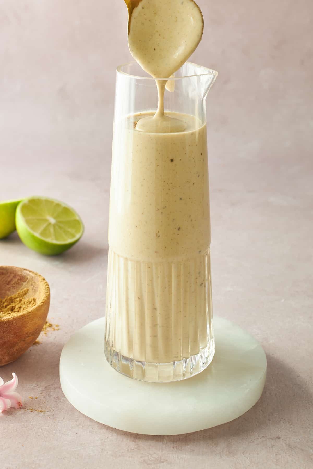 A glass container of tahini dressing.