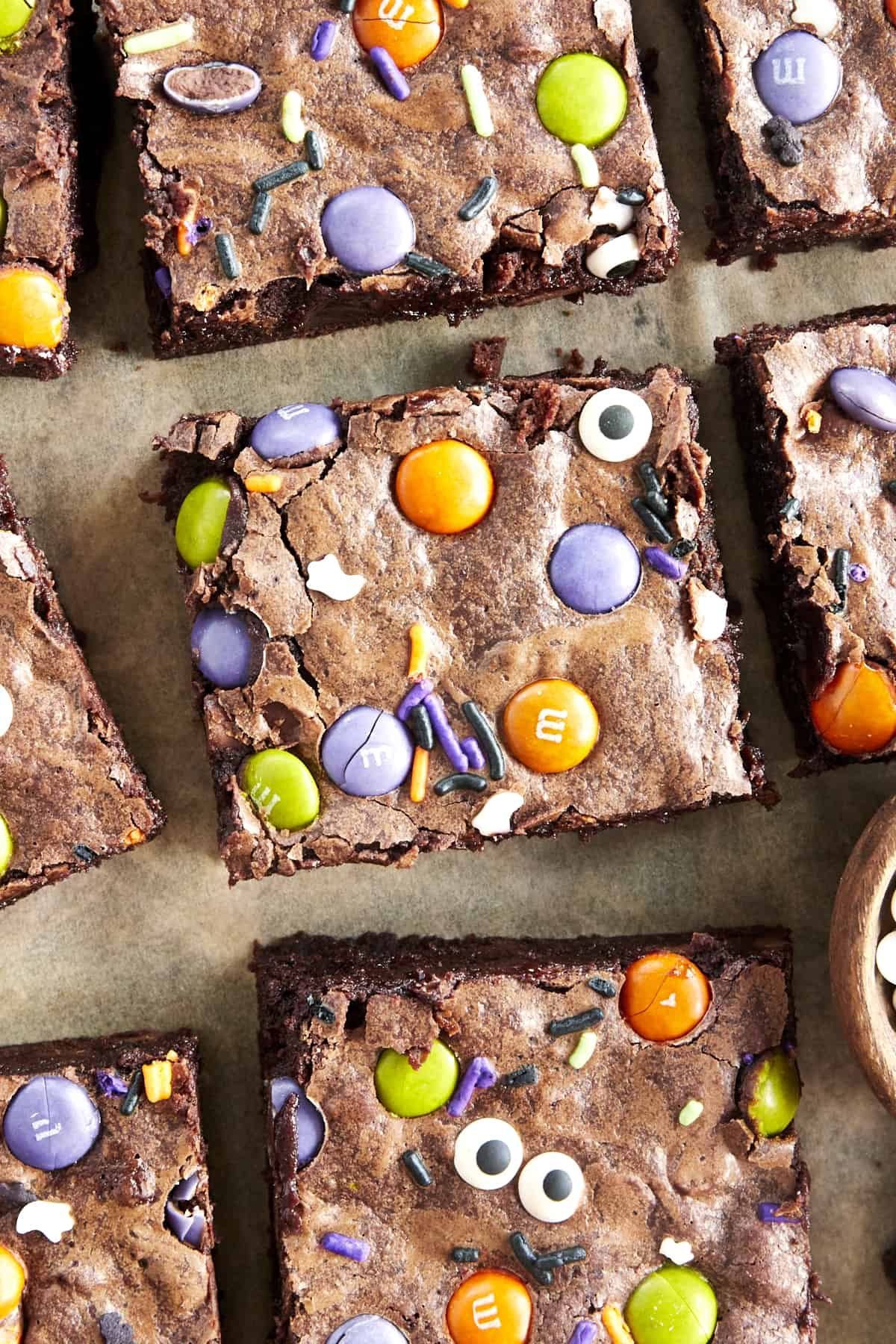 Square Halloween brownies on parchment paper.