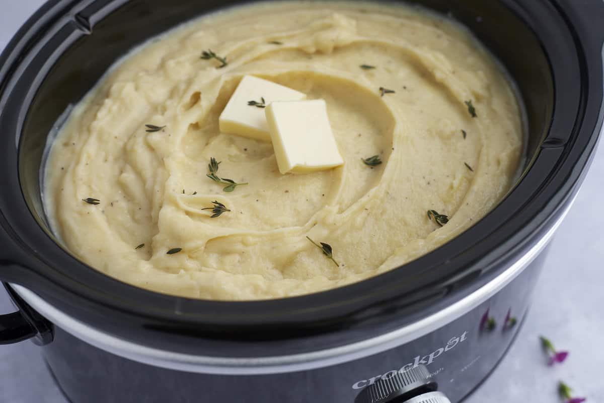 overhead of mashed potatoes in a crockpot with butter