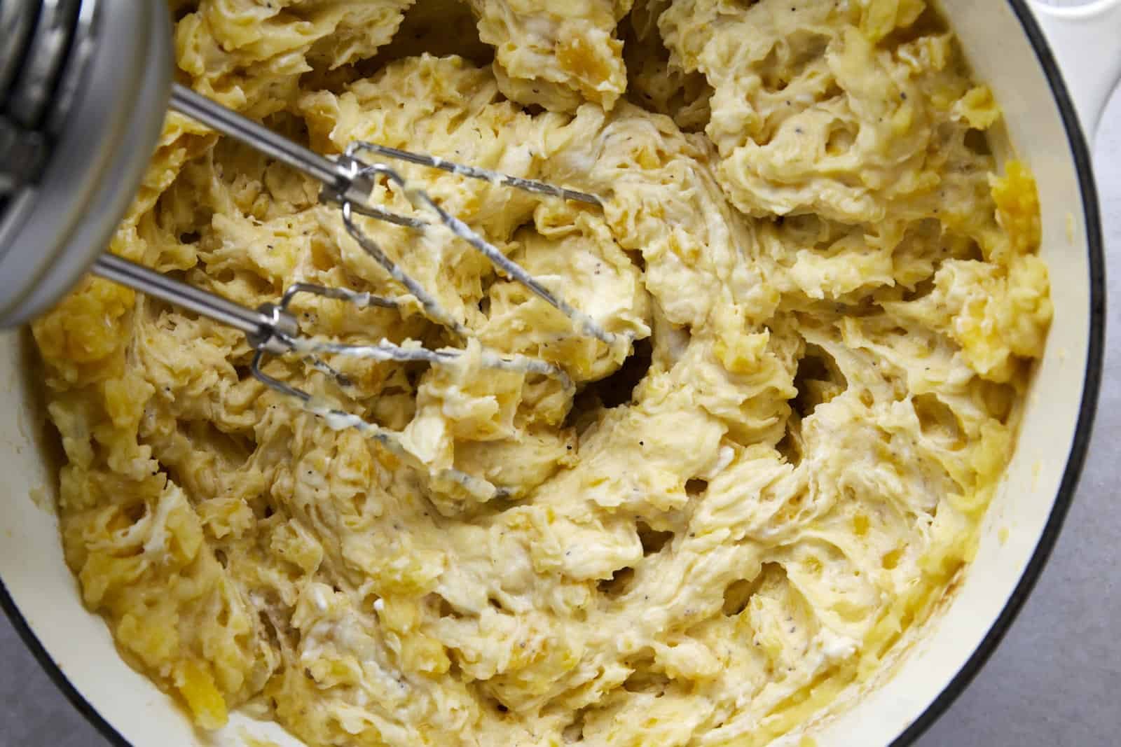 A mixer blending mashed potatoes.