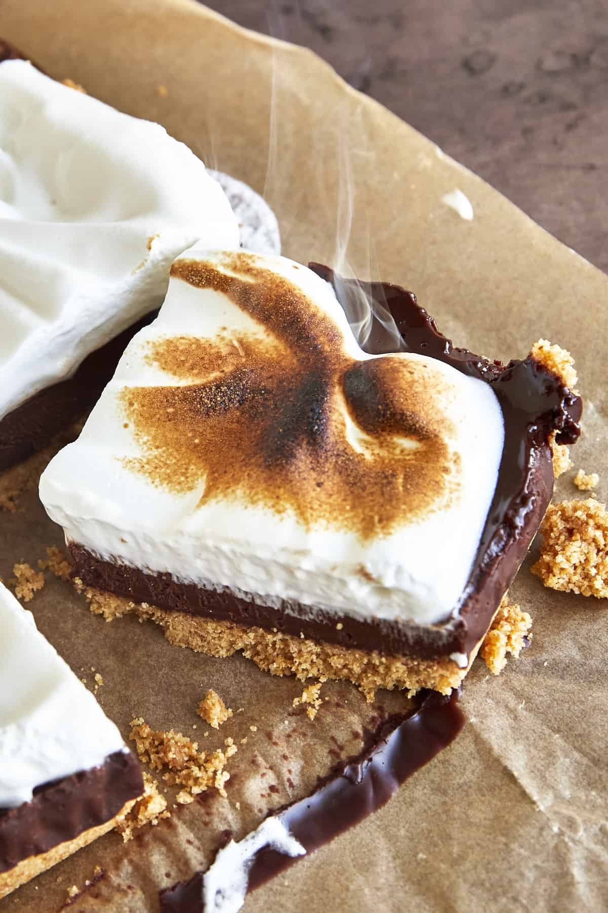 A s'mores bar smoking from being torched with a blow torch.