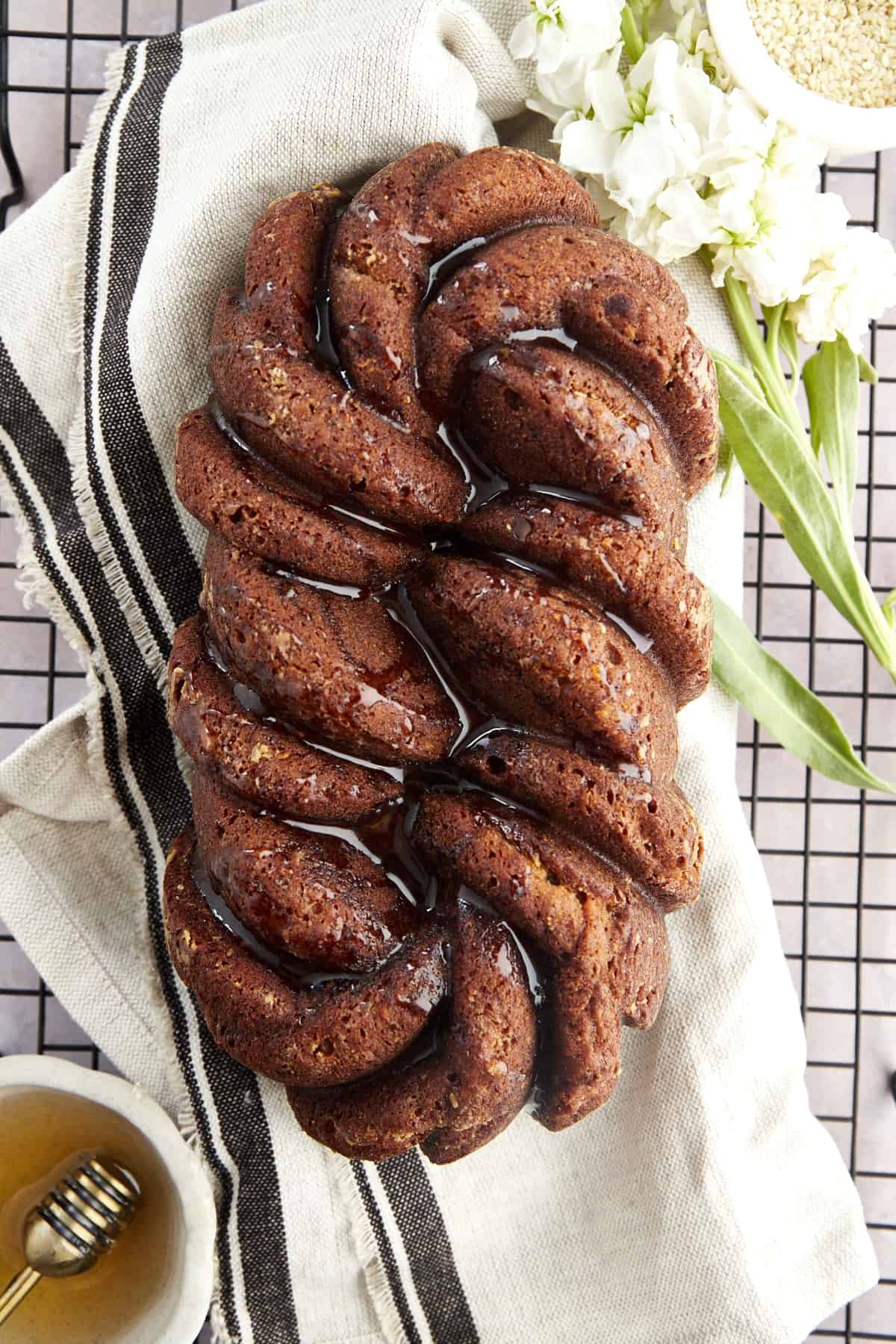 Overhead image of a loaf of tahini banana bread topped with honey.