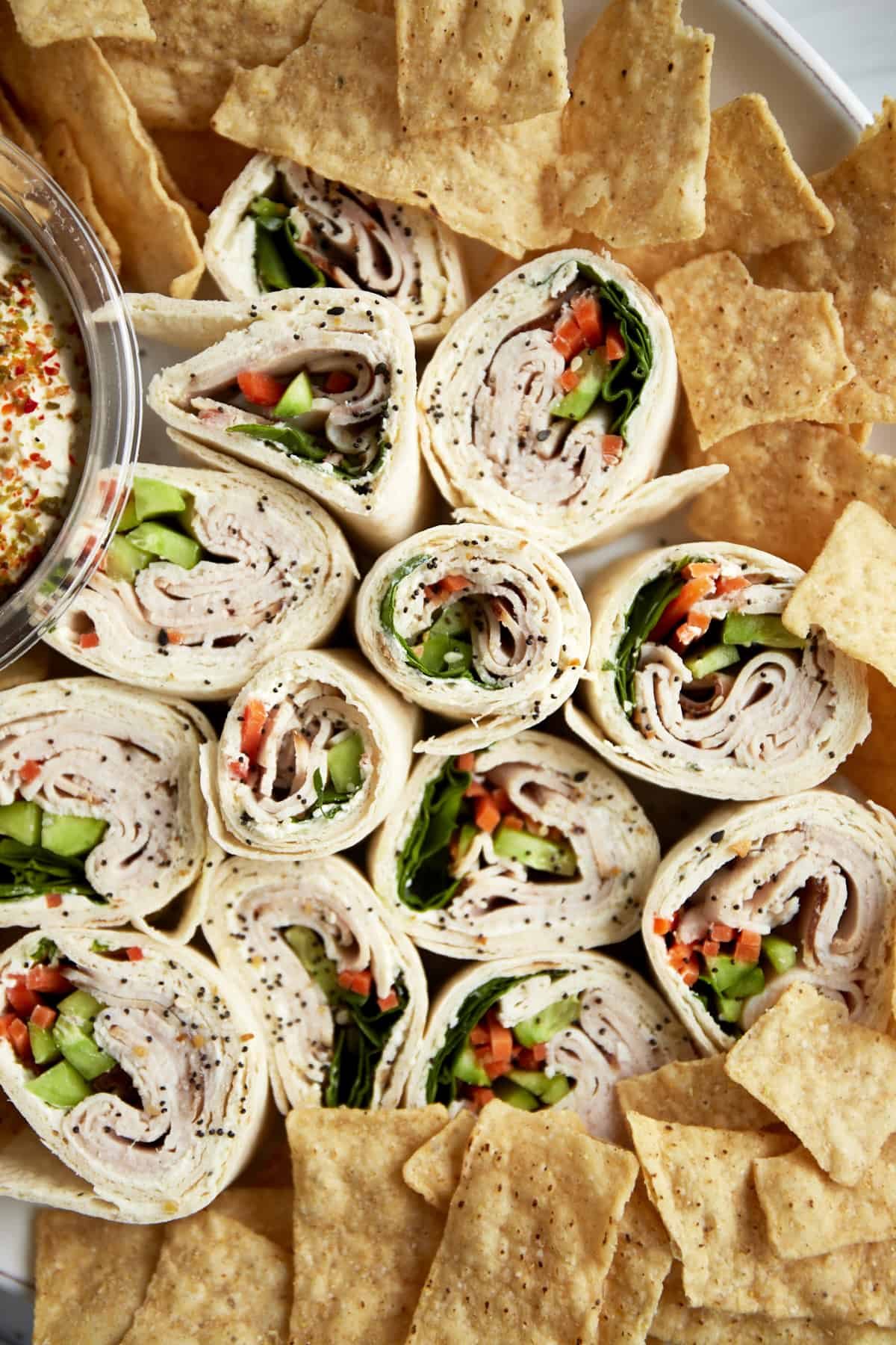 Turkey pinwheel sandwiches on a plate with chips.