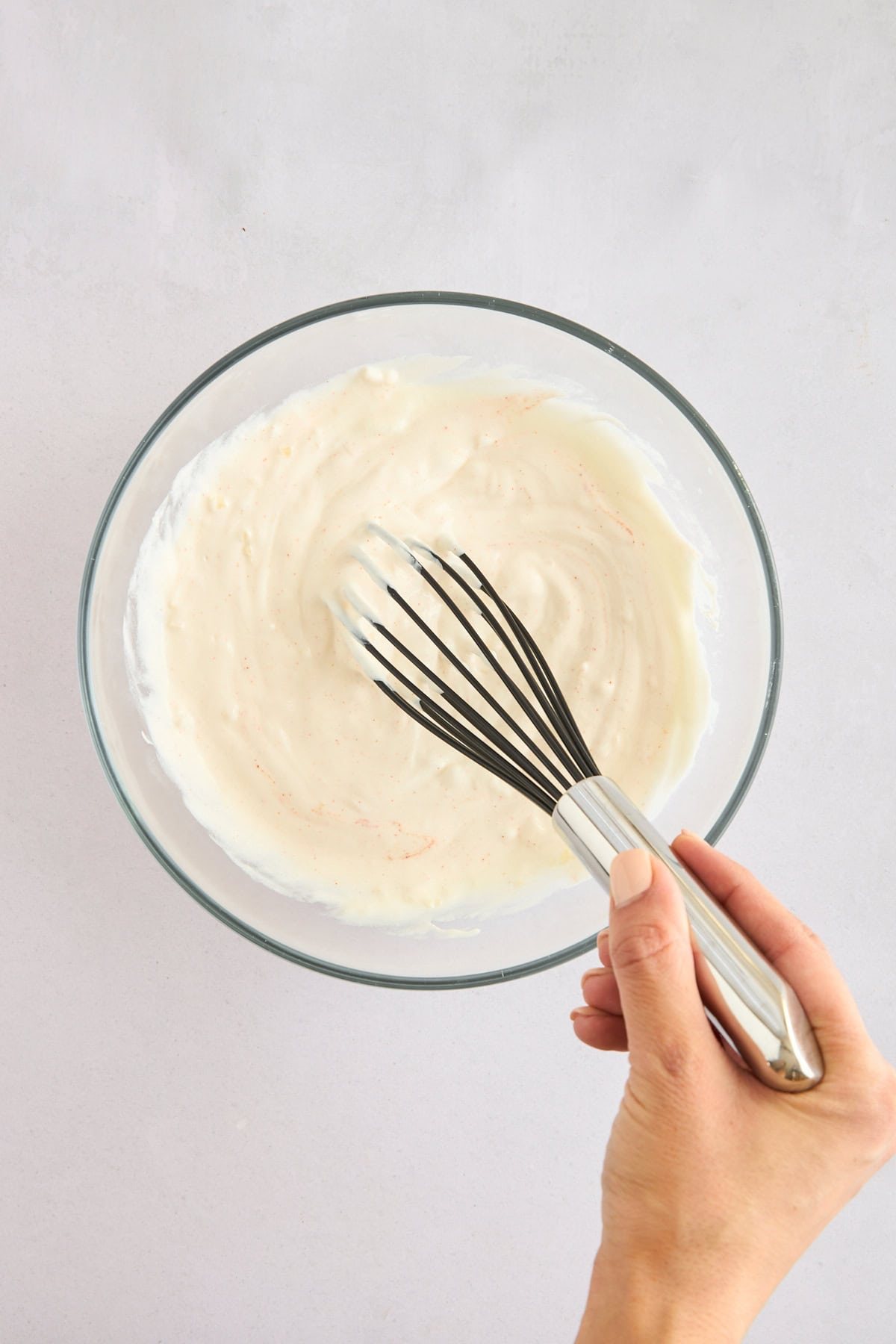 Garlic yogurt sauce being whisked.