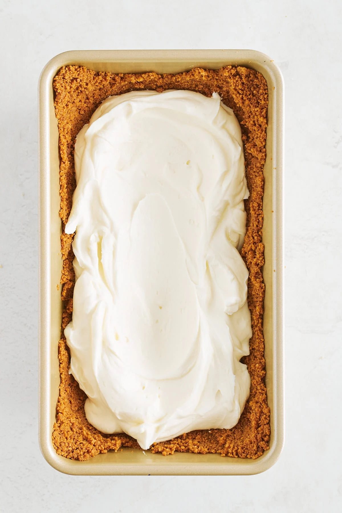 Cheesecake filling pressed into a Biscoff cookie crust in a loaf pan.