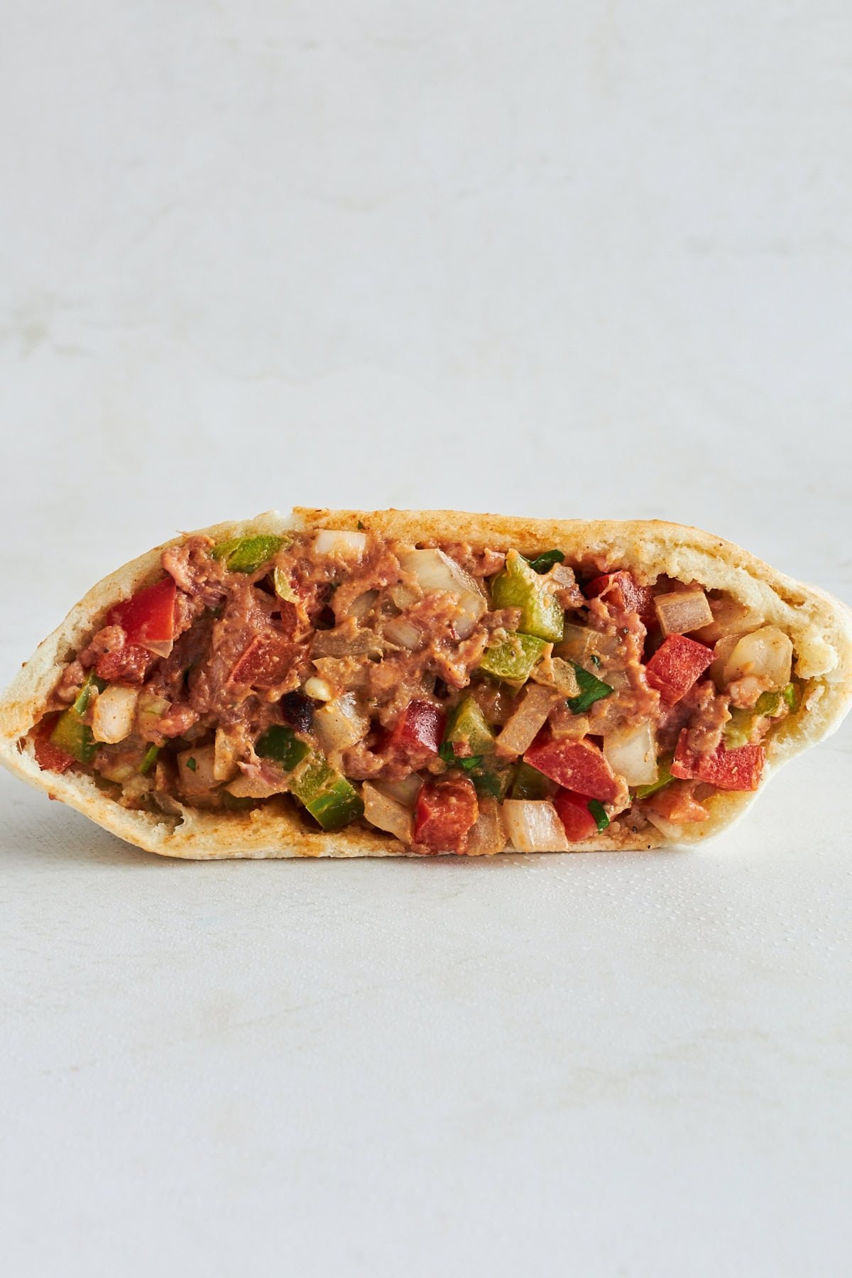 An unbaked hawashi pita pocket showing the filling inside.