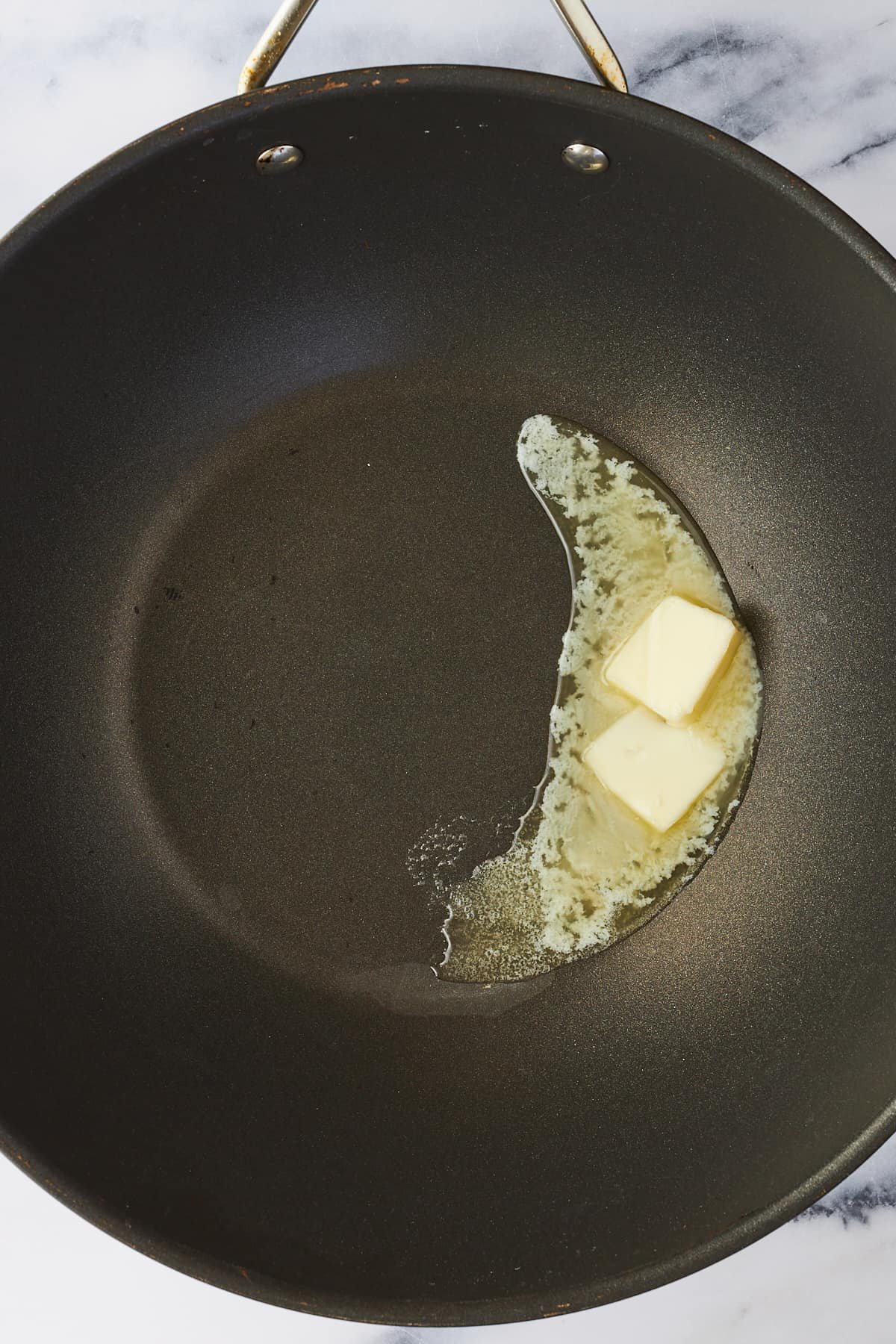 Butter melting in a wok.