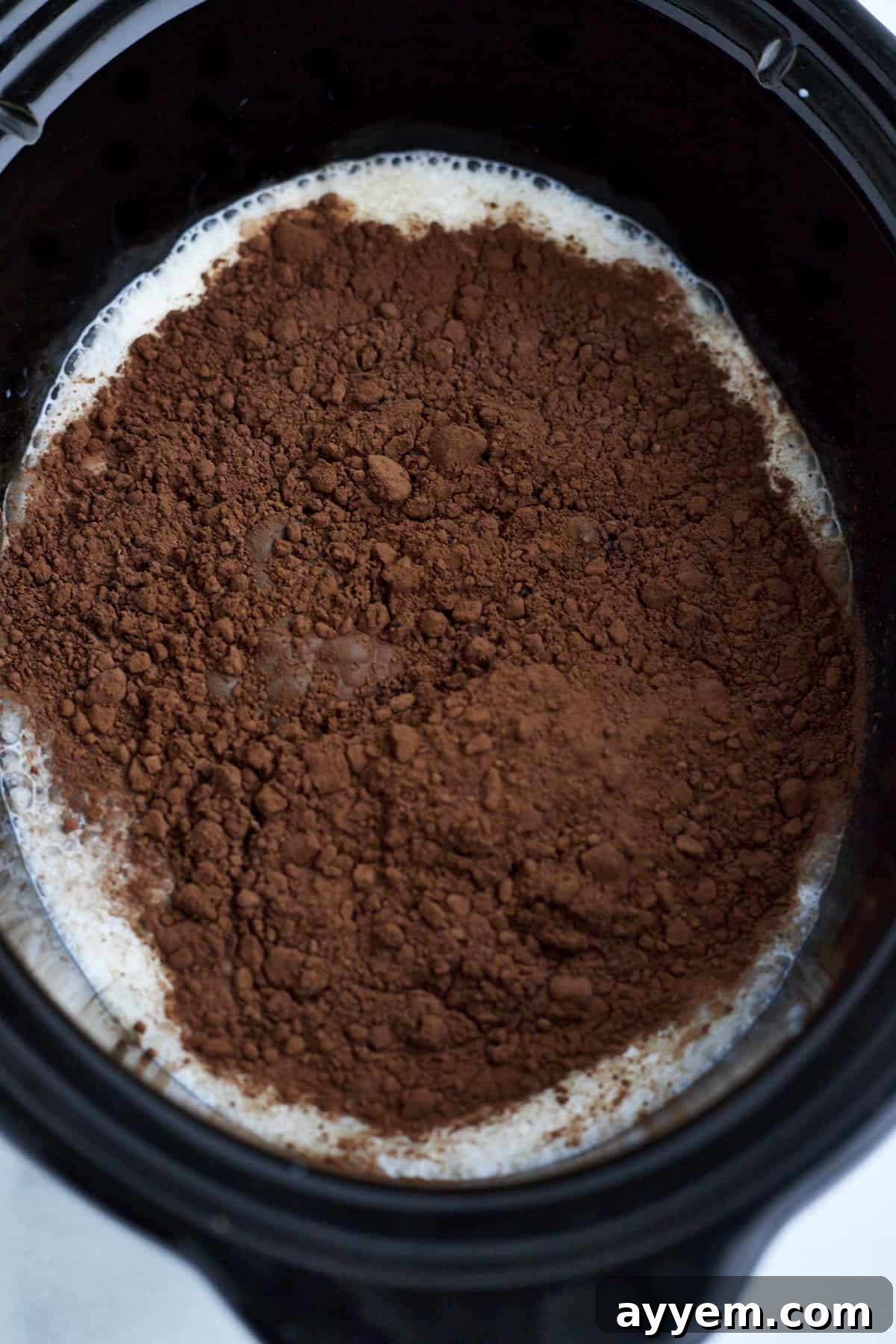 Ingredients laid out on a kitchen counter, ready to be combined for making hot chocolate in a slow cooker.