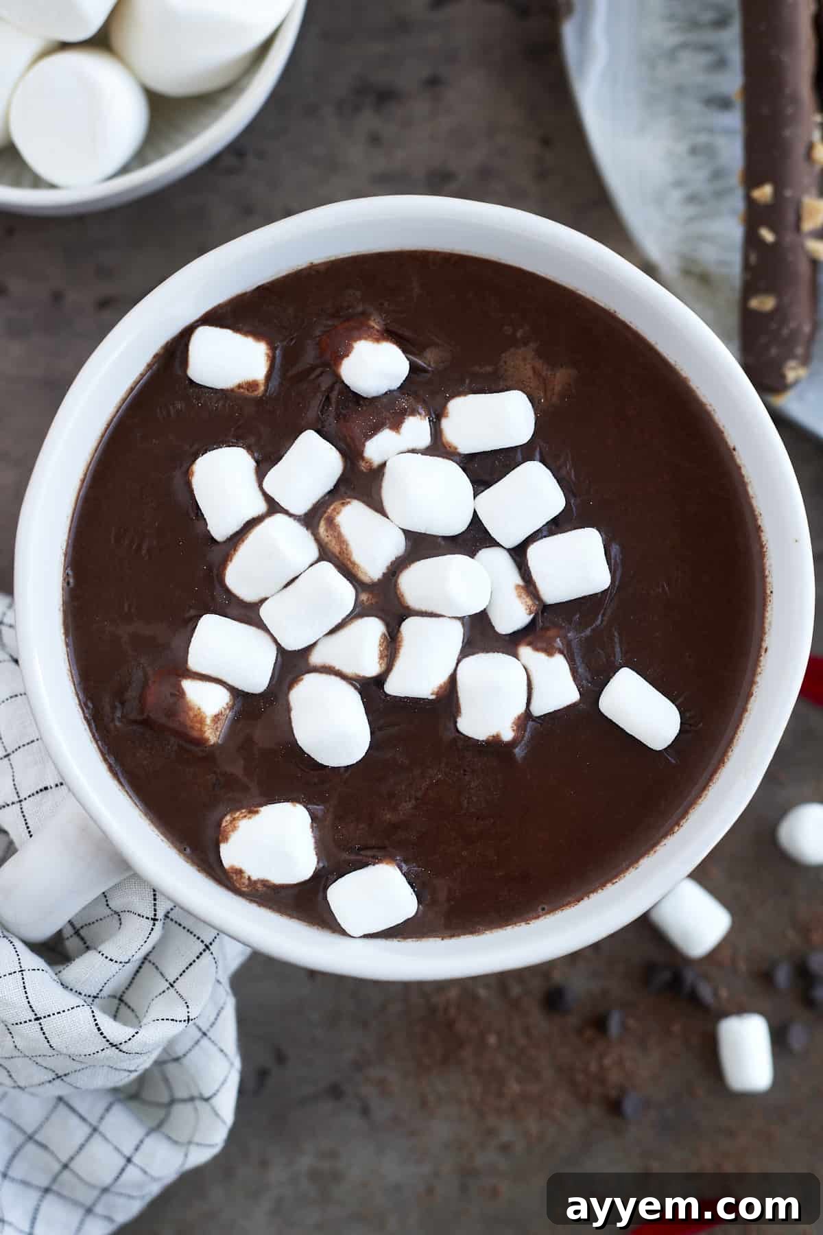 A close-up of a mug of slow cooker hot chocolate with espresso, generously topped with soft white marshmallows.