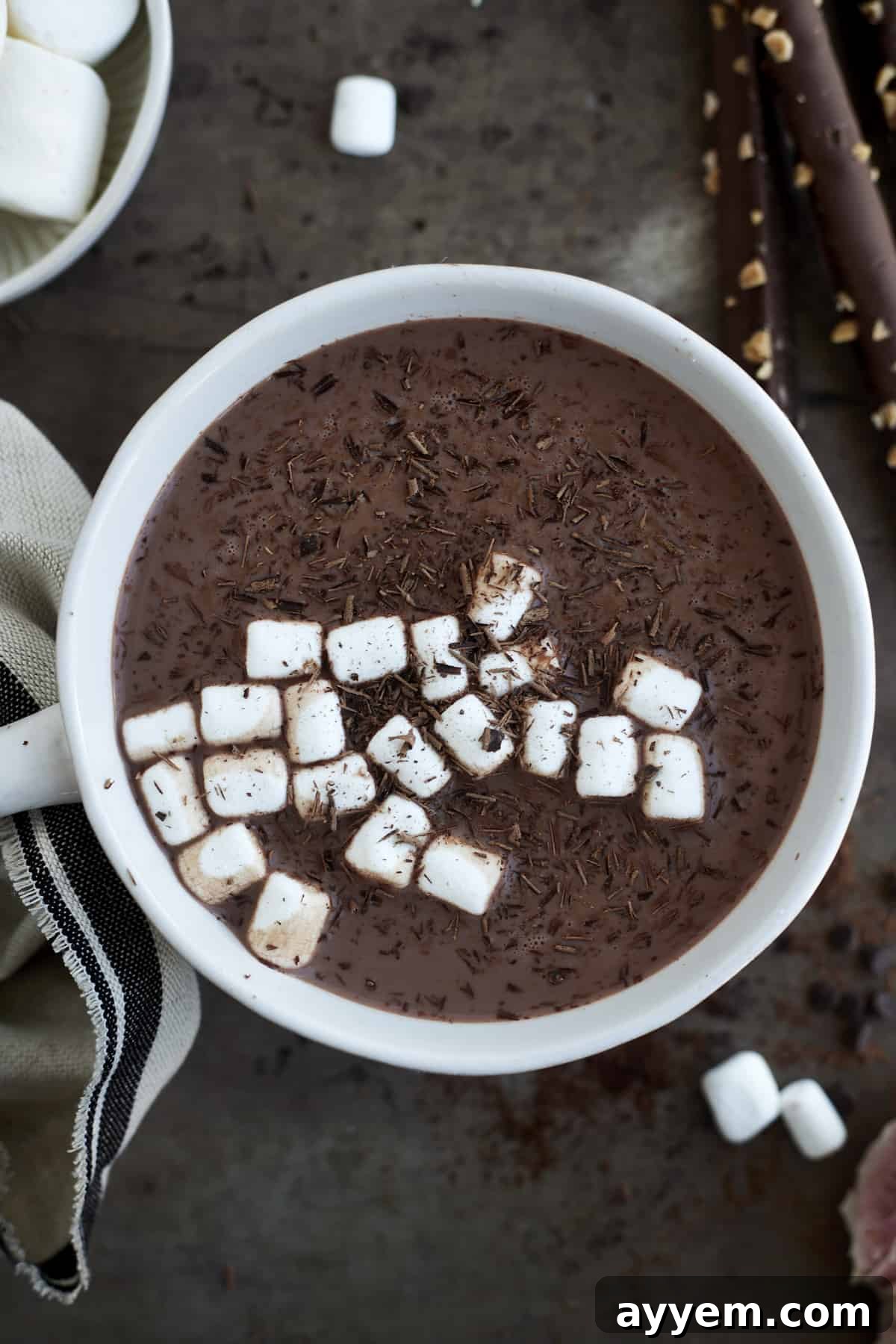 A beautifully presented mug of slow cooker hot chocolate with espresso, garnished with mini marshmallows and delicate chocolate shavings.