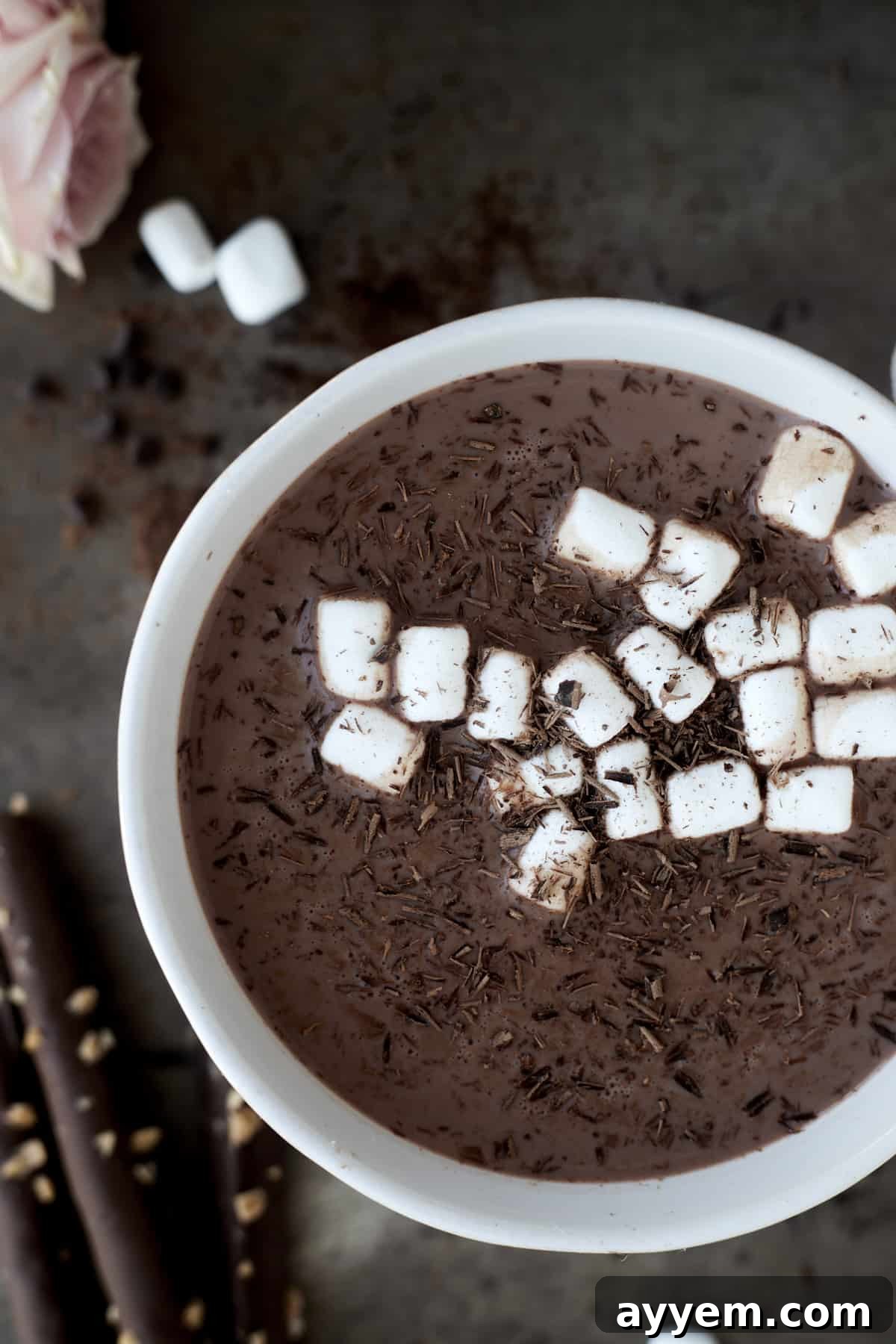 A close-up image of a mug filled with slow cooker hot chocolate and espresso, beautifully topped with mini marshmallows and delicate chocolate shavings, inviting a warm sip.