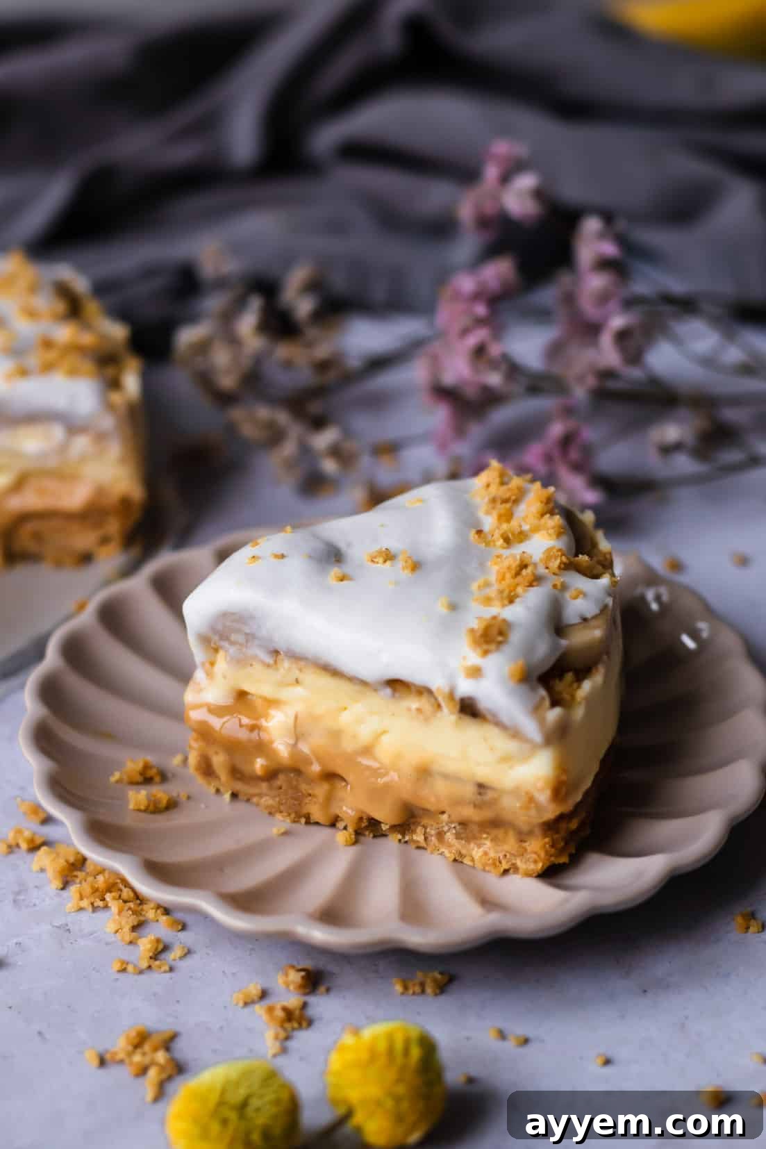 A single piece of Banoffee Cream Pie on a light beige plate, garnished with a sprinkle of graham cracker crumbs, highlighting its inviting layers and perfect for a satisfying dessert.
