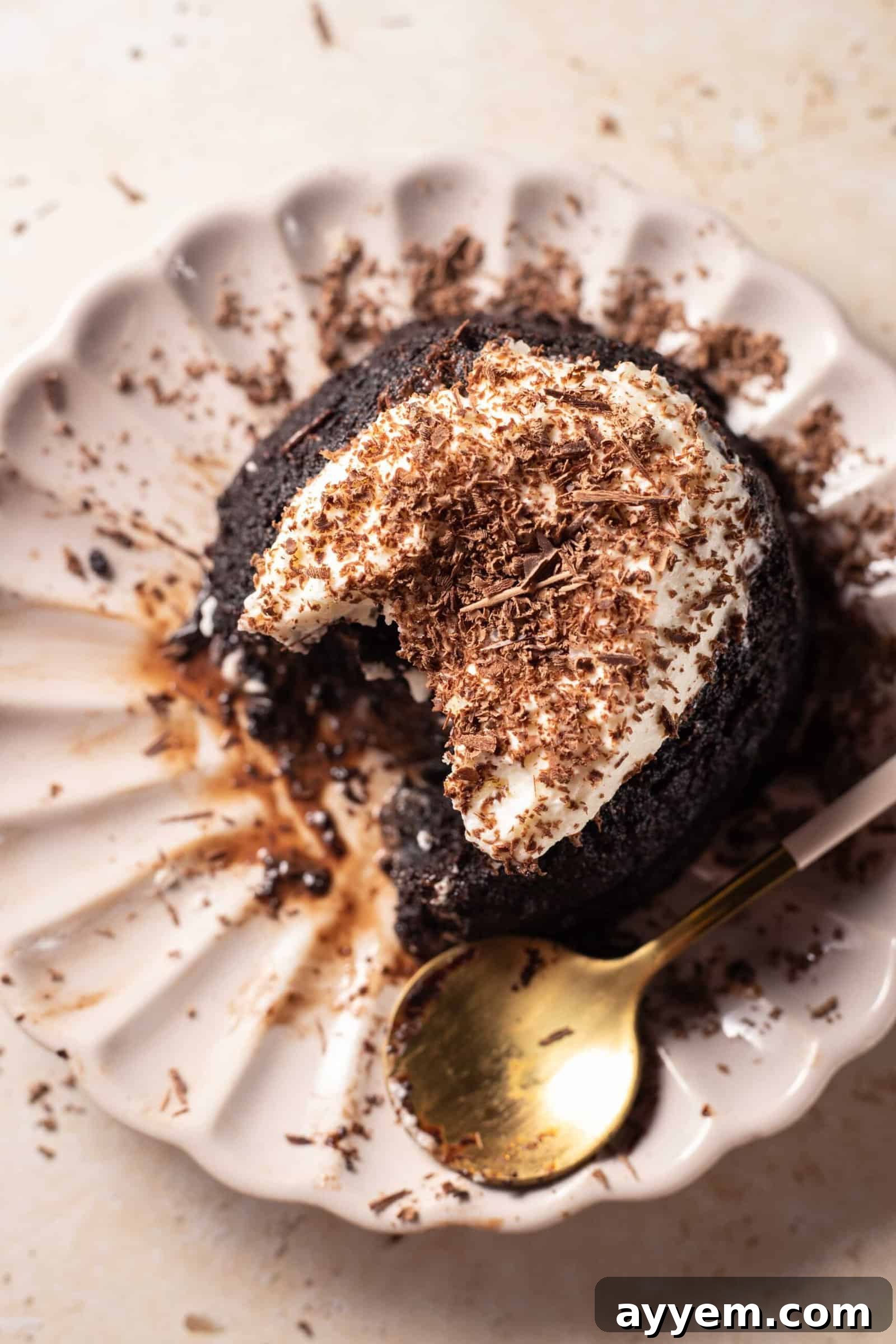 A delicious hazelnut chocolate lava cake on a plate, with a spoonful removed, revealing the molten chocolate interior. The cake is dusted with powdered sugar and ready to be savored.