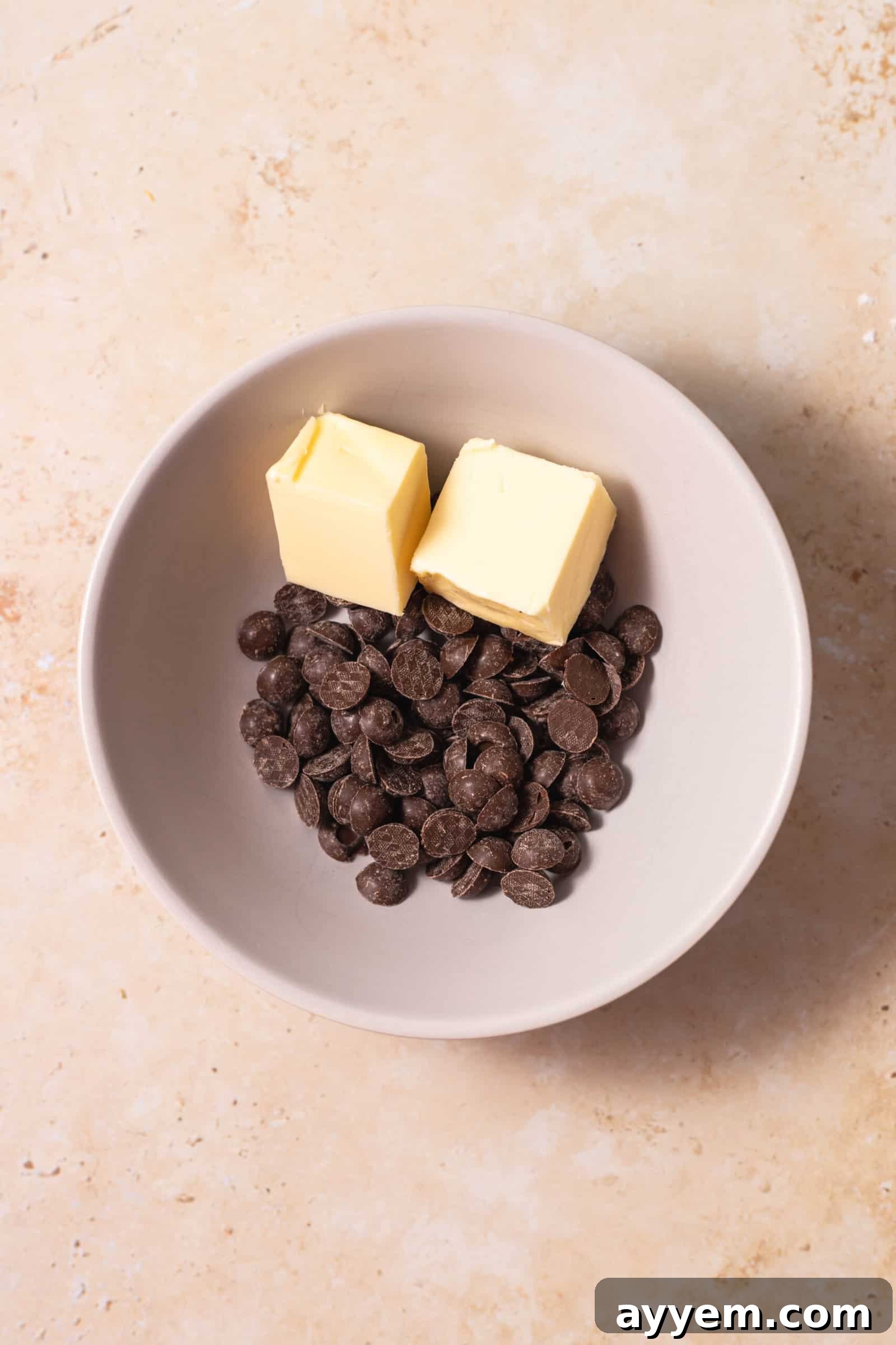 Chocolate chips and butter ready to be melted in a bowl, showcasing the simple, high-quality ingredients for the lava cake.