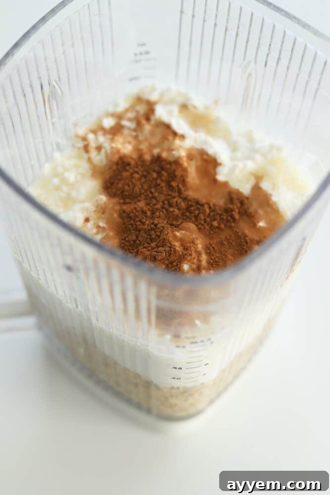 A high-speed blender filled with a smooth, light-colored batter, indicating the quick and easy preparation process for cottage cheese protein pancakes.