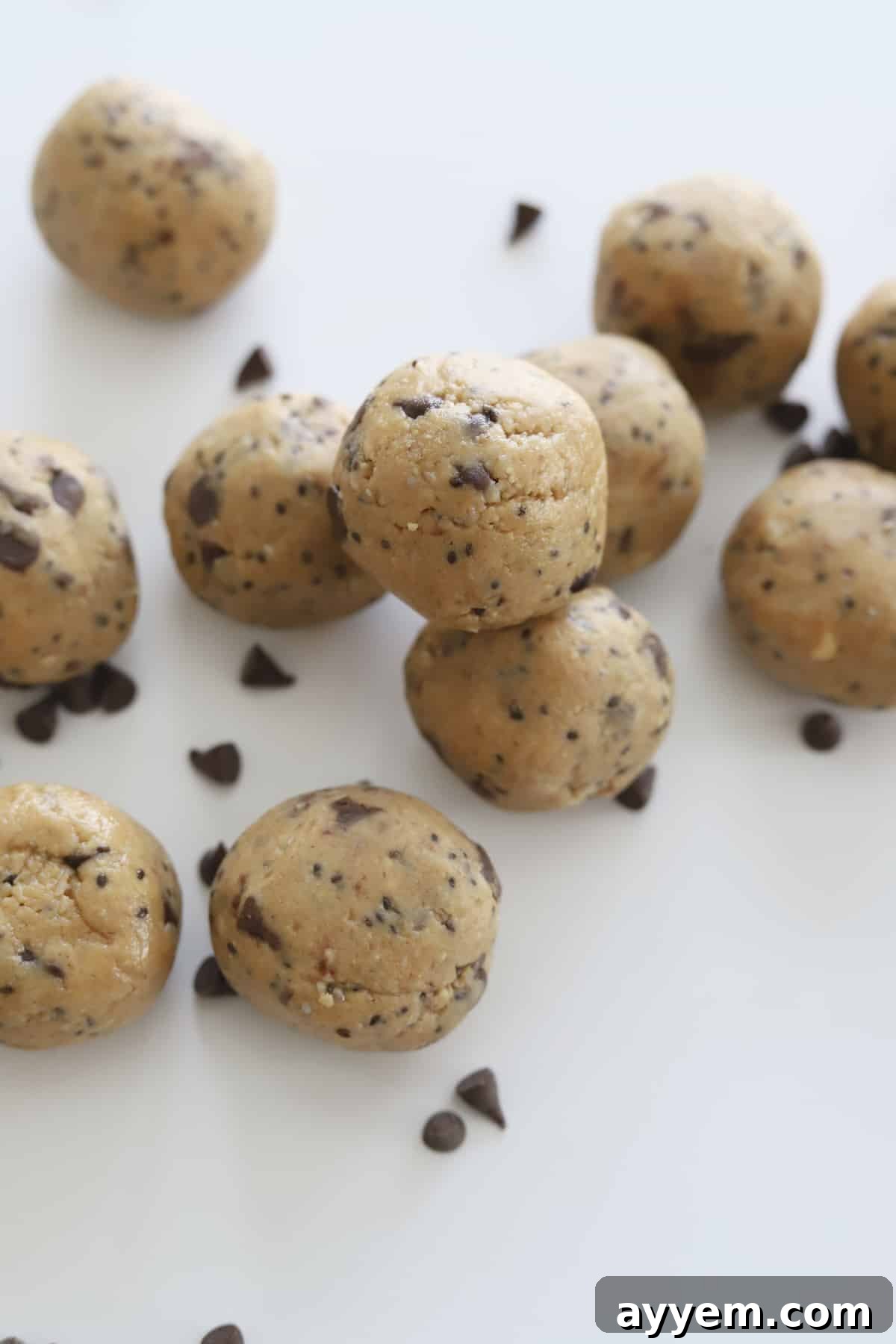 A vibrant display of peanut butter energy balls, generously speckled with chocolate chips, promising a healthy, no-bake, gluten-free, dairy-free, and refined sugar-free snack experience.