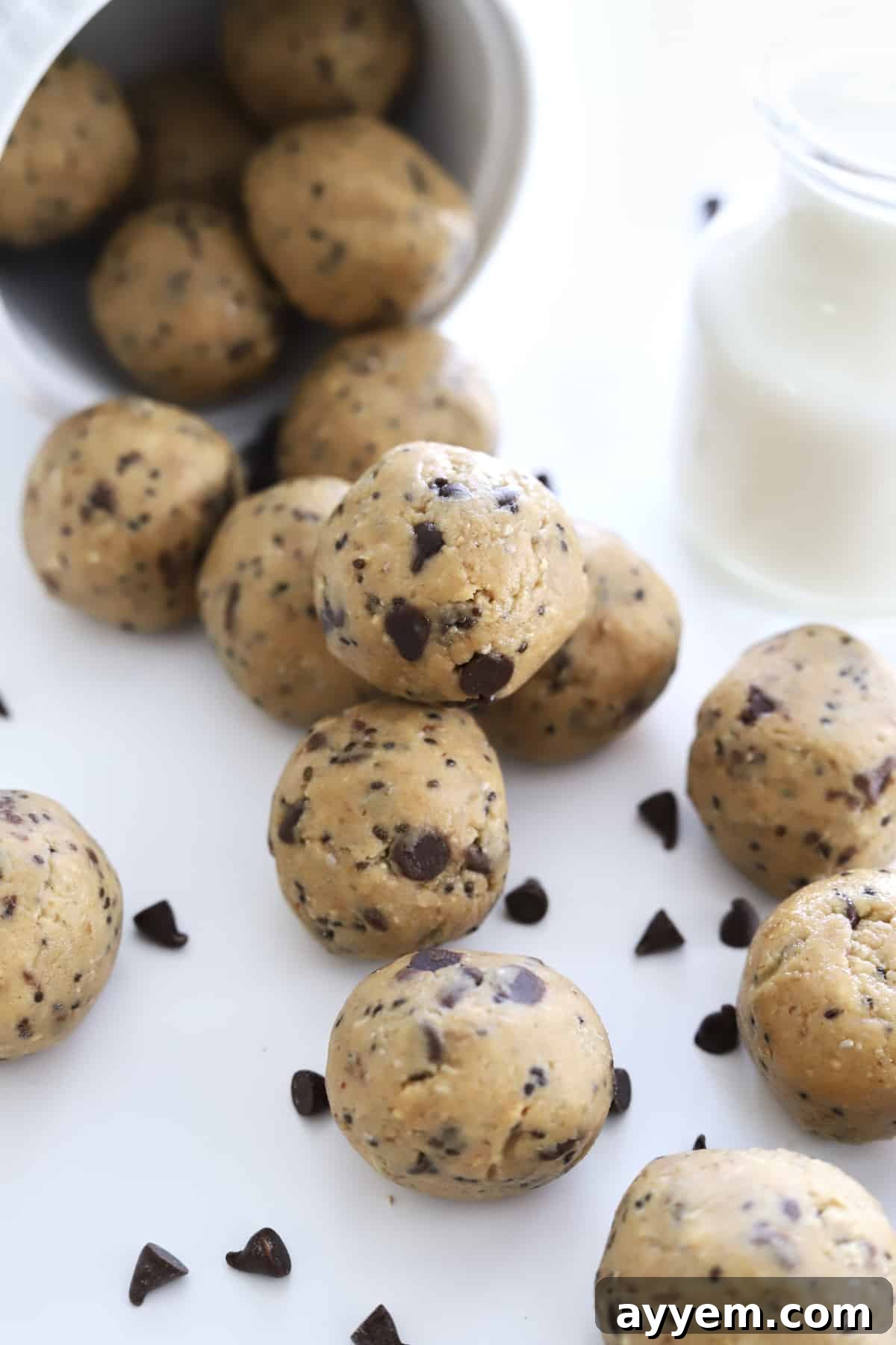 Peanut Butter Energy Balls spilling out of a cup with chocolate chips.
