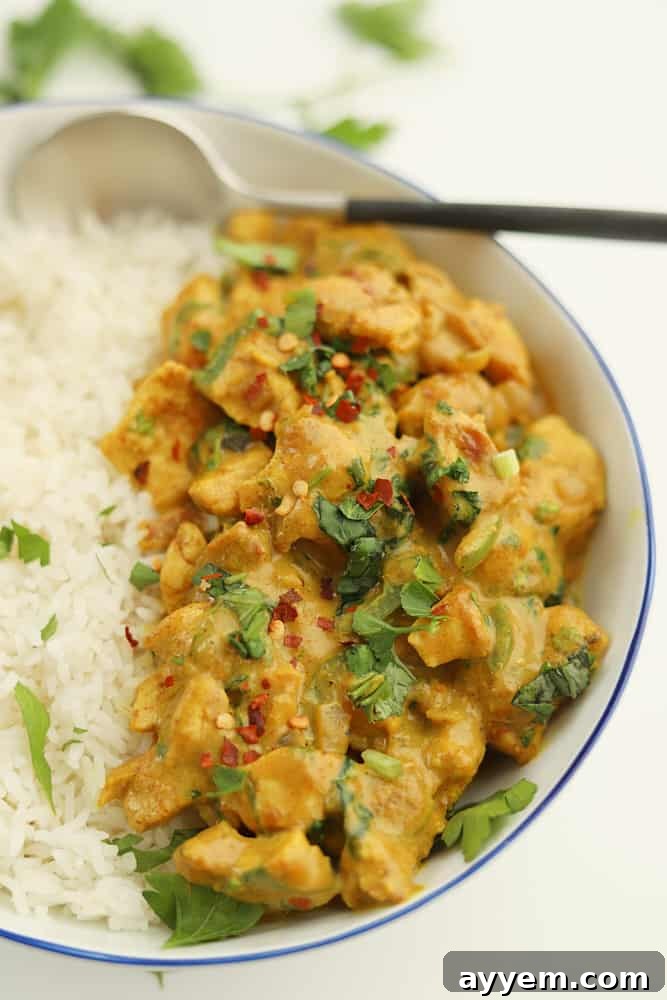 Thai coconut curry chicken served over white rice, garnished with fresh herbs