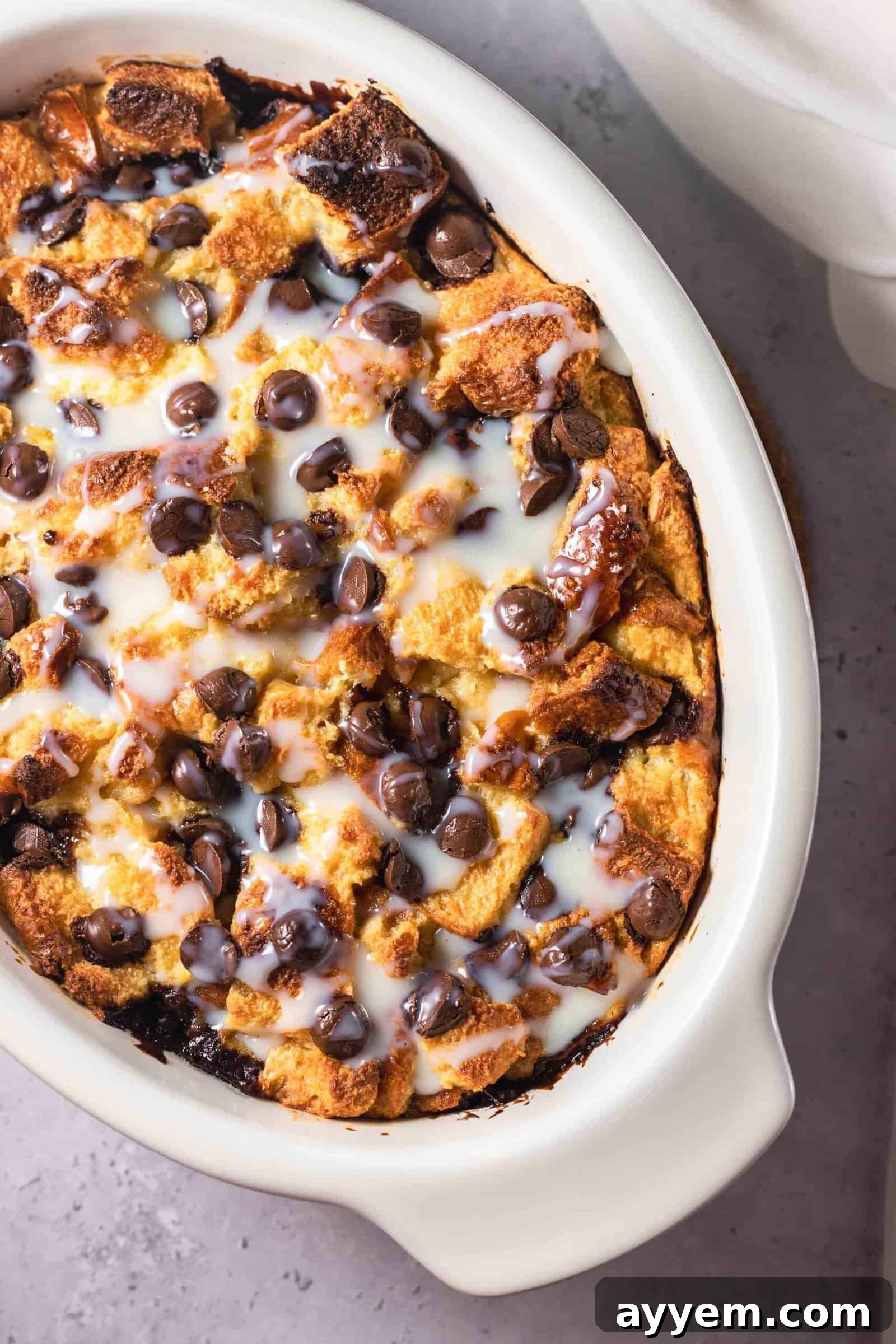 an oval baking dish full of tres leches bread pudding topped with chocolate chips
