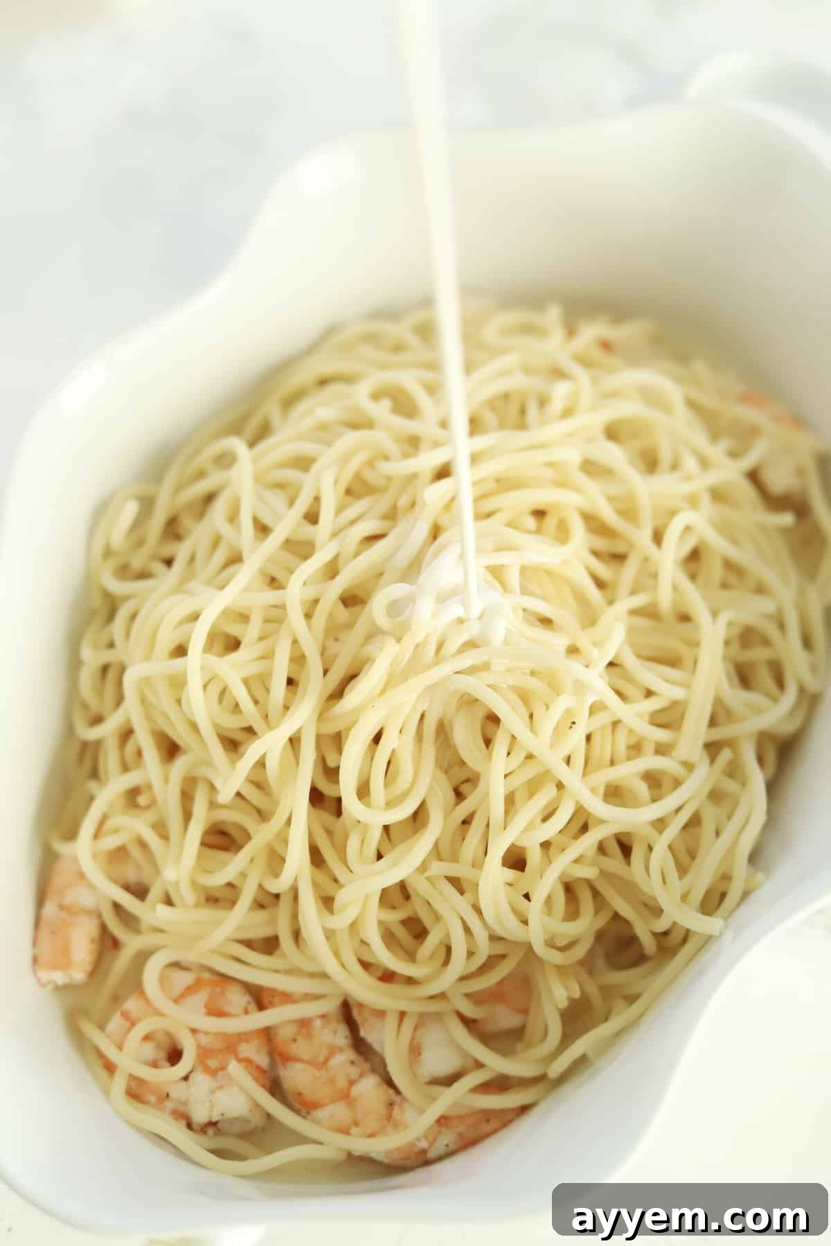 Golden Garlic Shrimp Bake 5 cooked shrimp in a baking dish with spaghetti and heavy cream