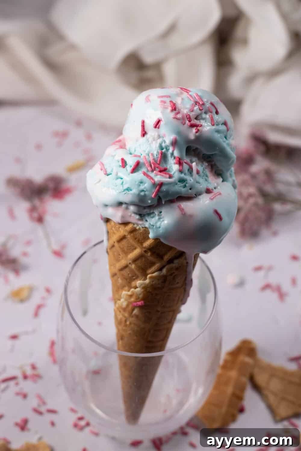 Sweet Dreams Cotton Candy Ice Cream 4 An ice cream cone generously stuffed with homemade cotton candy ice cream, presented elegantly in a wine glass, making a sophisticated yet fun dessert statement.
