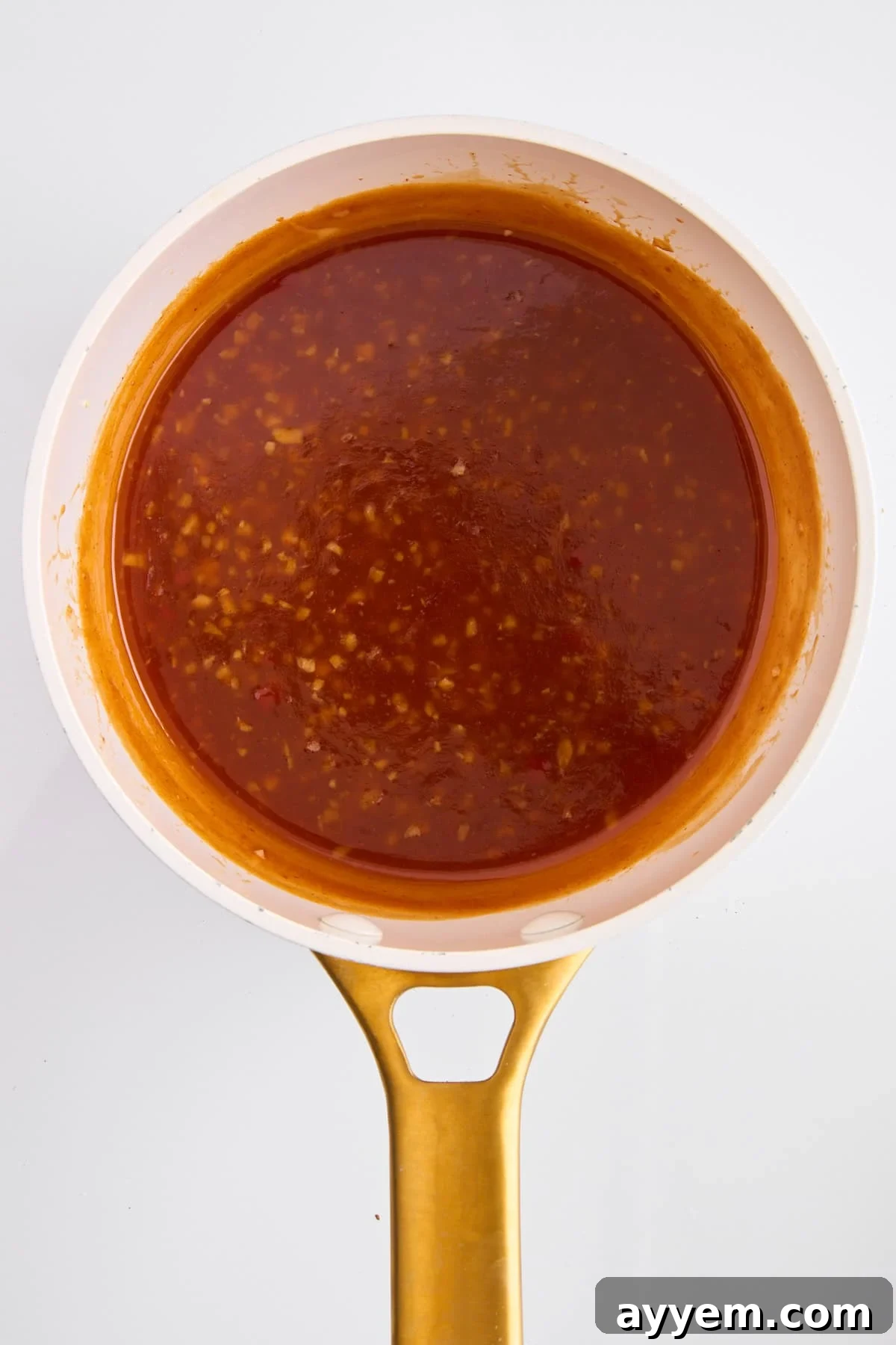 Orange chicken sauce simmering in a pot.