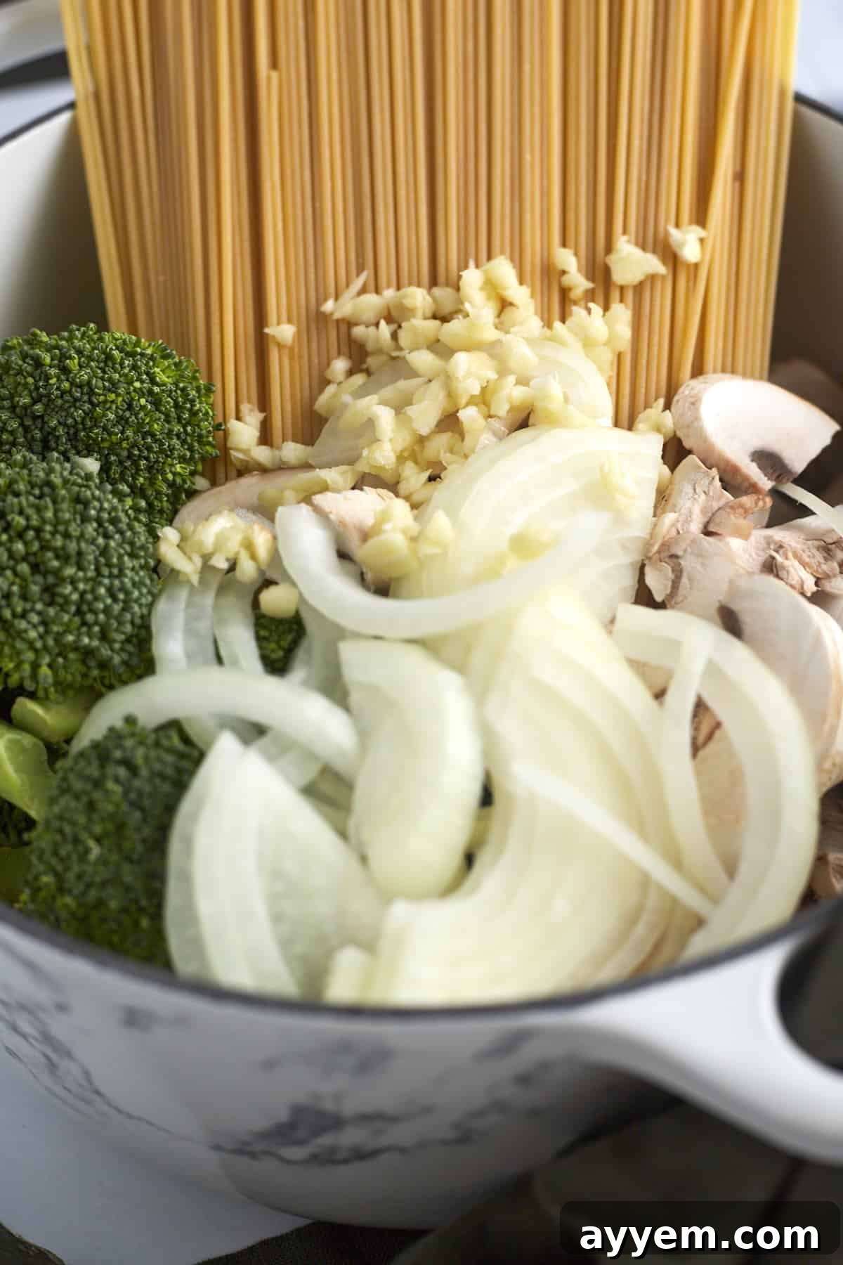 Effortless Primavera One-Pot Wonders 3 spaghetti noodles, garlic, onions, mushroom, and broccoli in a pot